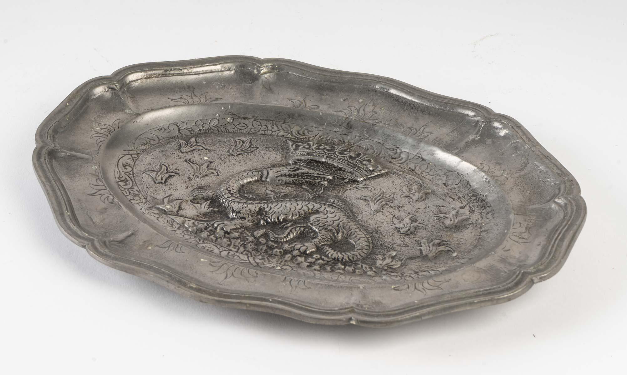 Decorative pewter tray with a crowned dragon motif.
Measures: H 2 cm, W 28 cm, D 20 cm.