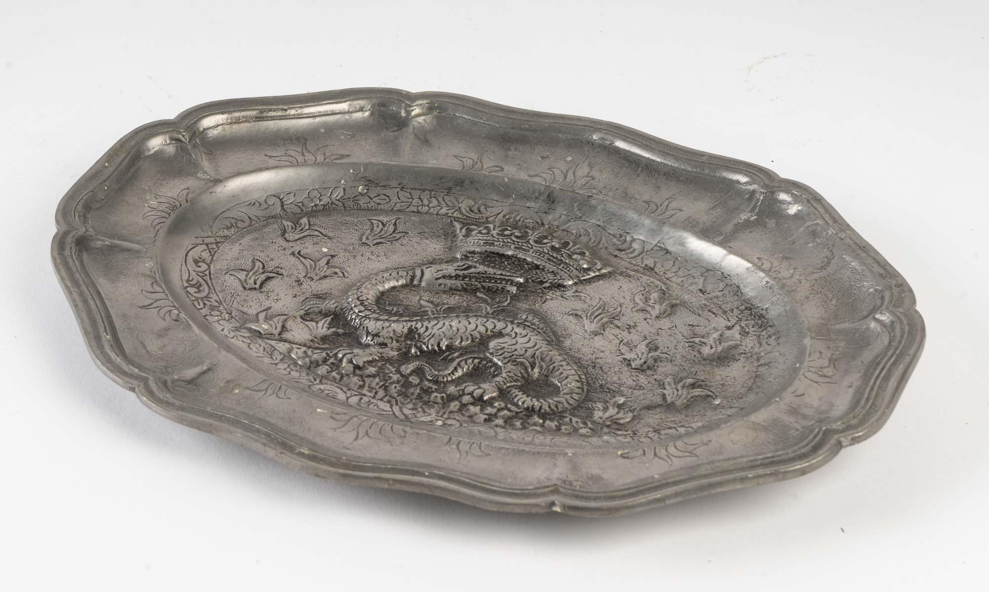 Bandeja decorativa de estaño con motivo de dragón coronado.
Medidas: Alto 2 cm, Ancho 28 cm, Fondo 20 cm.