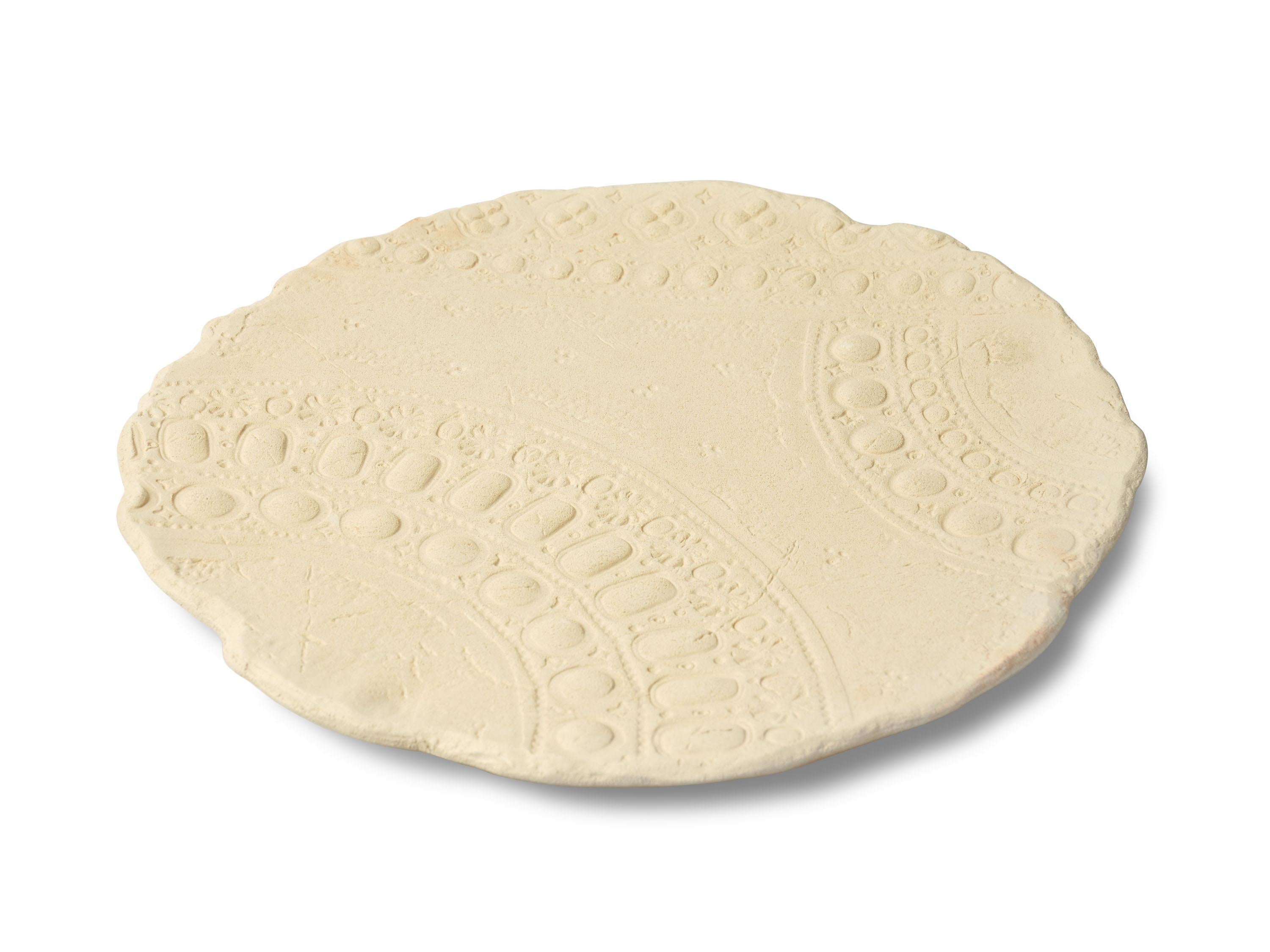 Decorative plate in fireclay, entirely handmade in Italy. The incredibly material finish has been left natural to highlight the beauty and uniqueness of this clay. The whiteness of its color is reminiscent of something ancient, consumed by the sea