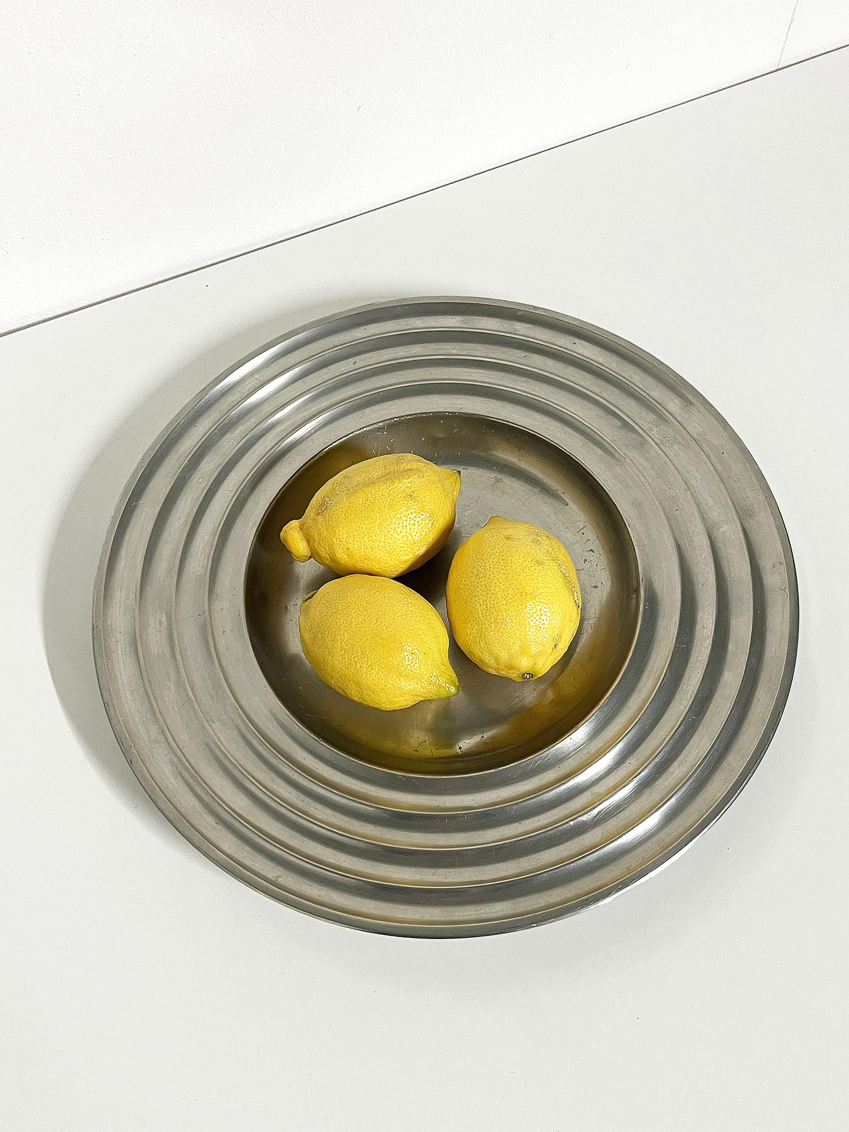 Cool plate in pewter, 20th century, most probably Scandinavian Modern. 
Signed with makers mark. 
Wear and patina consistent with age and use. 
Pewter patina, scratches and dents. 
Uneven shaped.