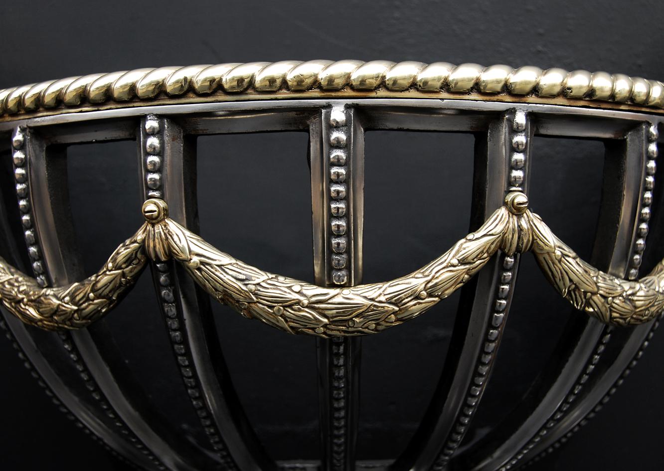 A decorative polished cast iron firegrate in the Regency style. The oval feet surmounted by shaped legs with Greek key pattern to feet, the semi circular burning area with beaded front bars and swags and rope moulding above. Reeded shaped ties to
