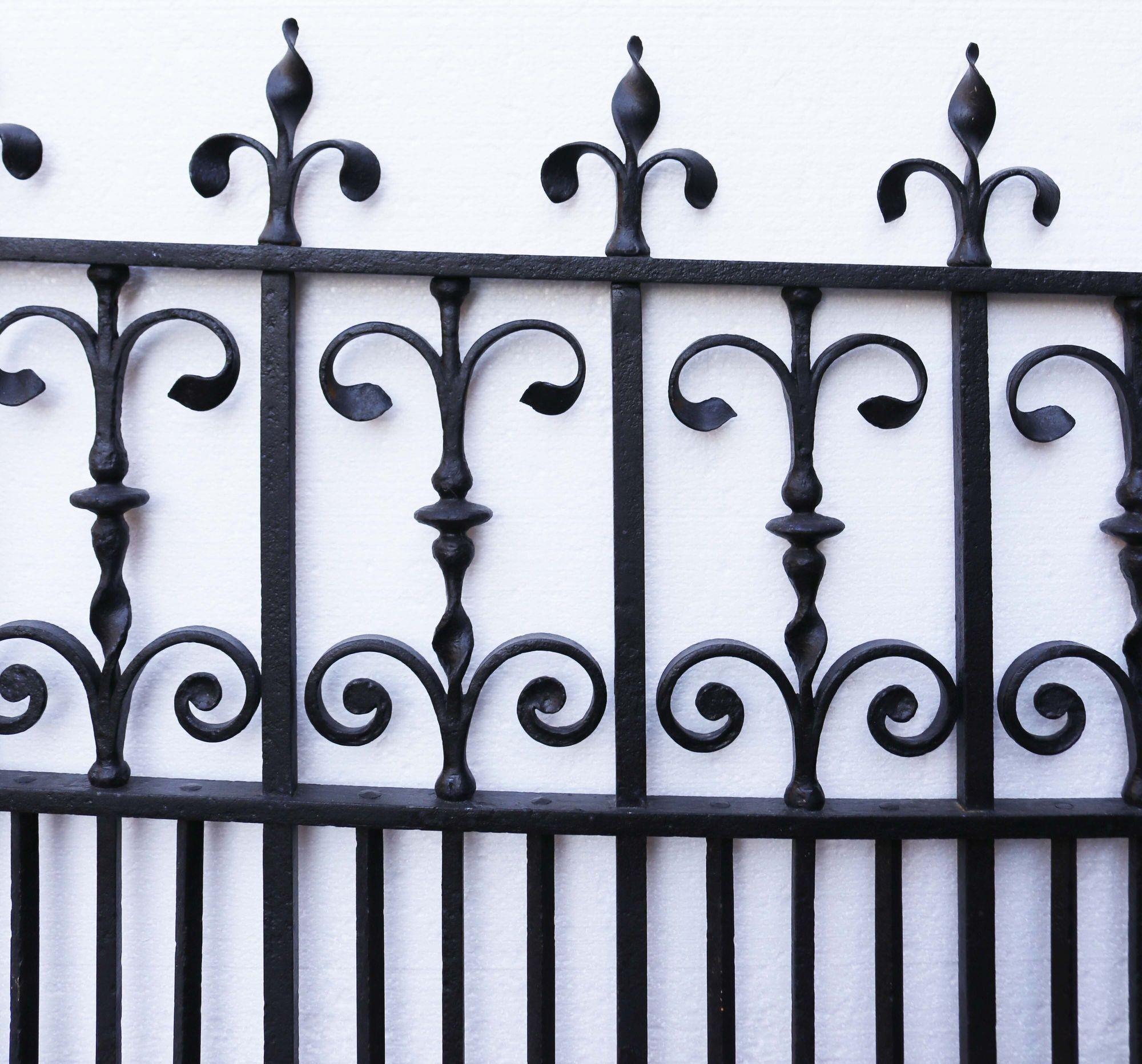 Decorative reclaimed iron gate. An English, blacksmith made side gate, finely detailed with scrollwork and foliage.
