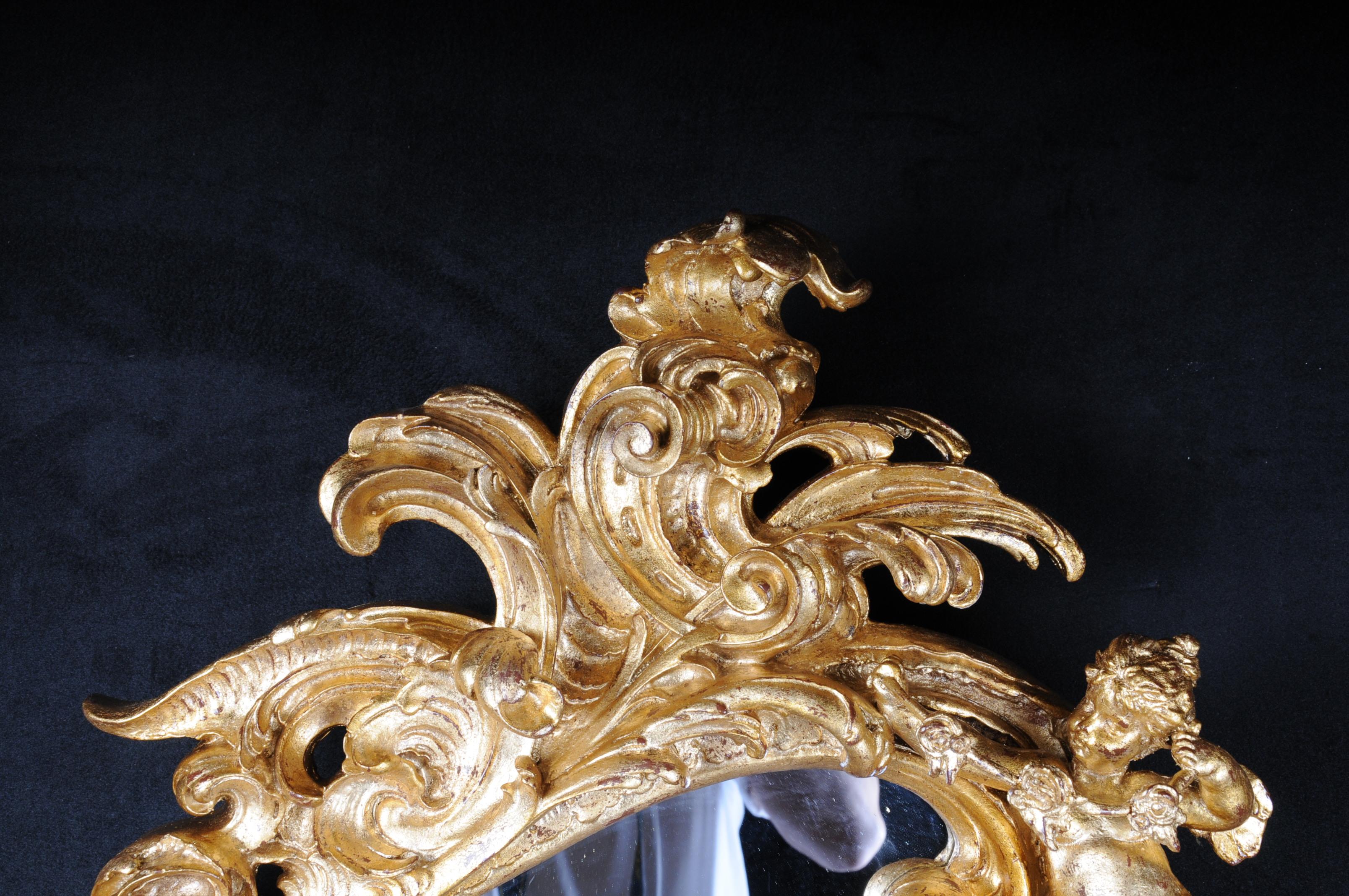 Miroir mural décoratif rococo / baroque avec putti, doré

Hêtre massif, finement sculpté, doré. Cadre de miroir en forme de rocaille. Couronne ajourée de rocaille. Cadre de miroir en forme de rocaille extrêmement frisée. Couronne de