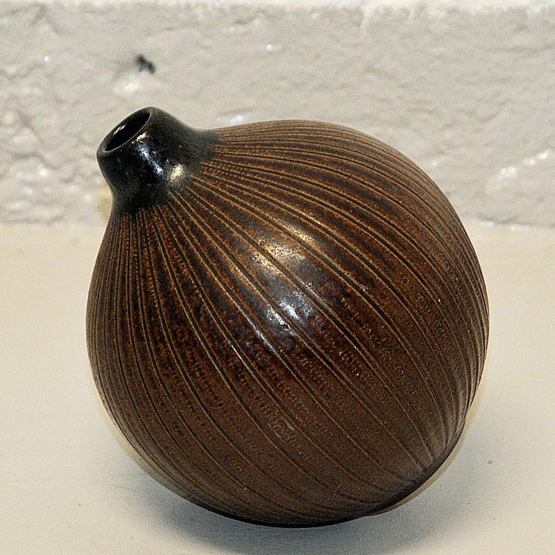 Lovely melonshaped and decorativ ceramic vase by Wallåkra Sweden 1950s. The vase has brown earth basic color and relieffed verical stripes all around the vase. Matt finish with silky surface. Perfect in the windshield or table with or without
