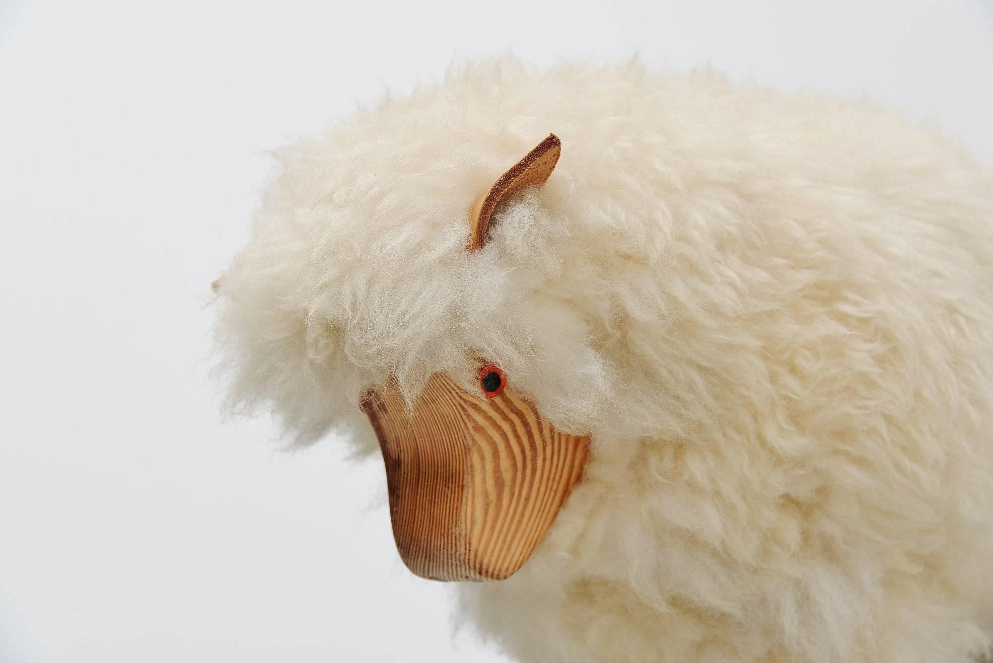 Very nice decorative sheep made by unknown manufacturer, Germany 1970. This sheep was made of solid pine wood and is covered with real sheep wool, its ears are made of leather. These sheep were designed as shop window decoration for blankets made of