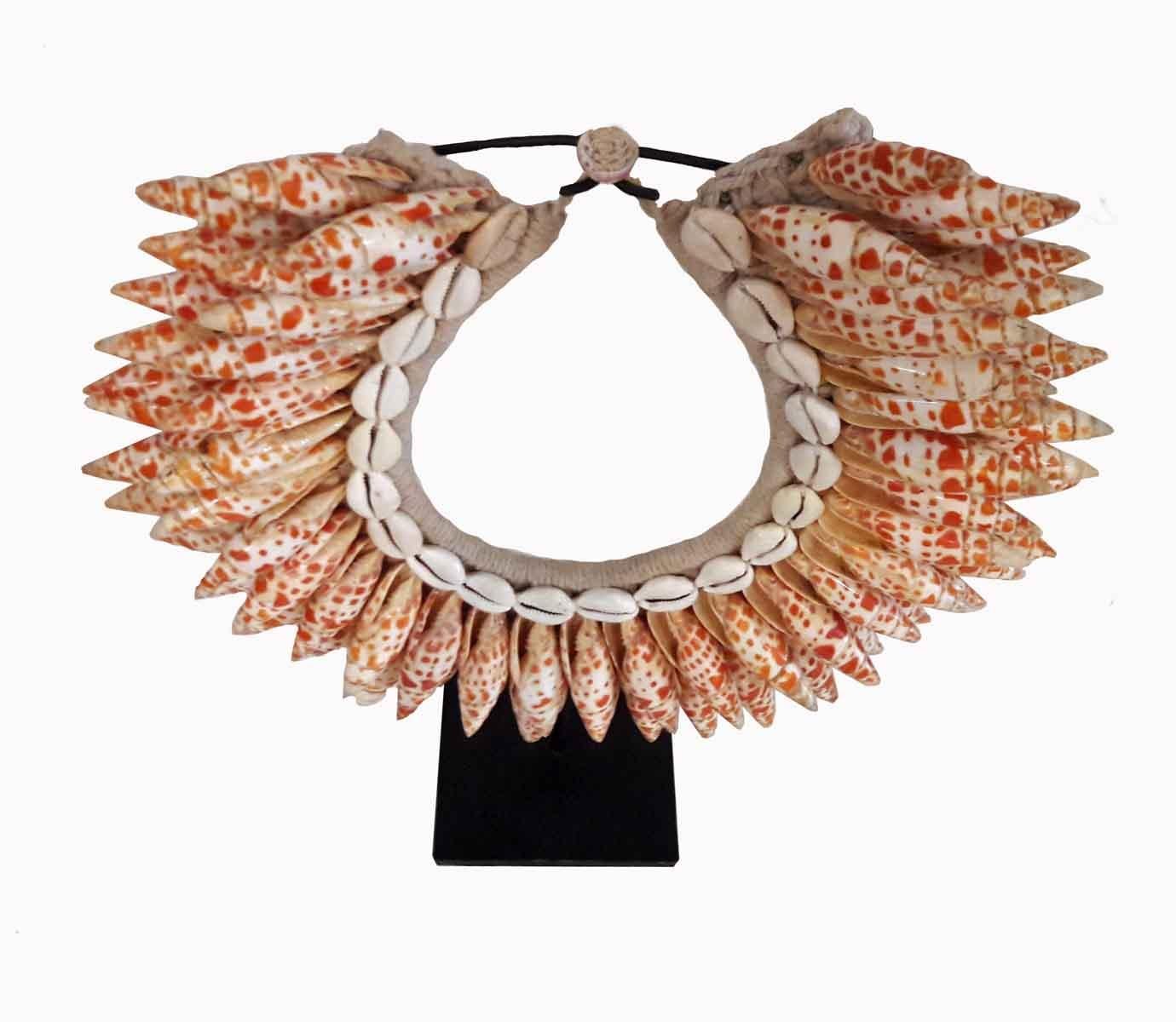 A handwoven seashell necklace from Bali, Indonesia. Small tiger conch and money cowry artfully arranged on a woven cotton base, mounted on a 4.5