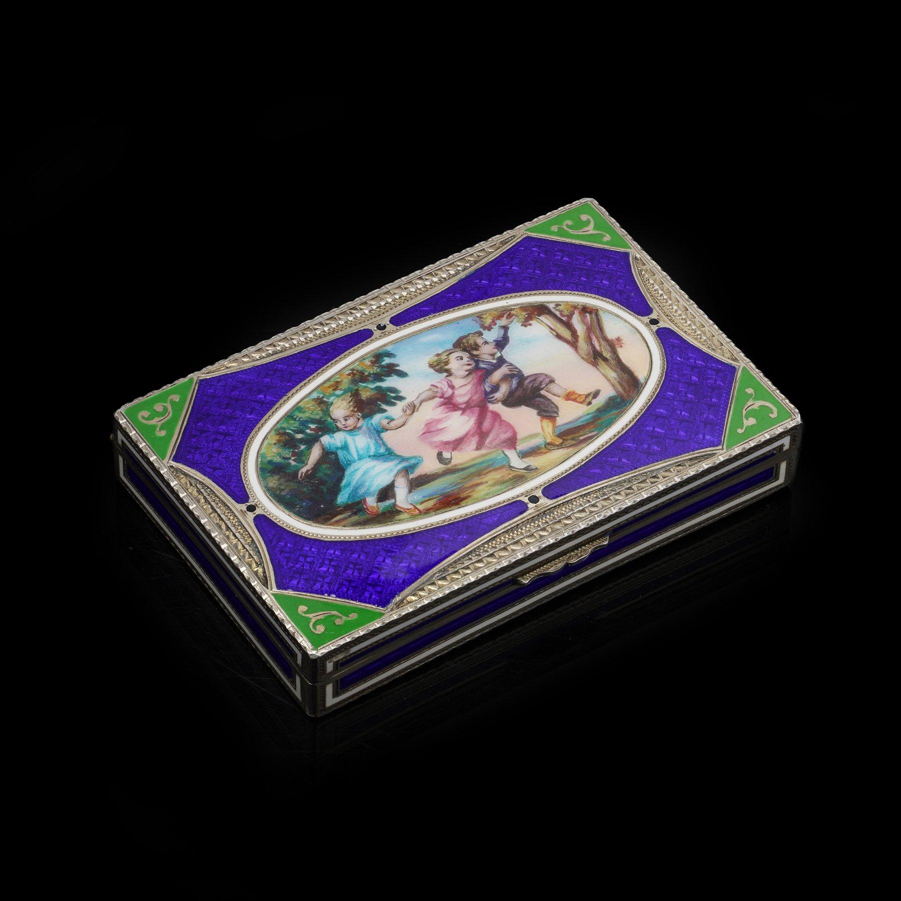Scatola rettangolare in argento e smalto finemente lavorata, con vivaci pannelli in smalto blu, verde e bianco che circondano una scena figurata dipinta a mano raffigurante bambini che giocano. Il rovescio presenta una decorazione in smalto