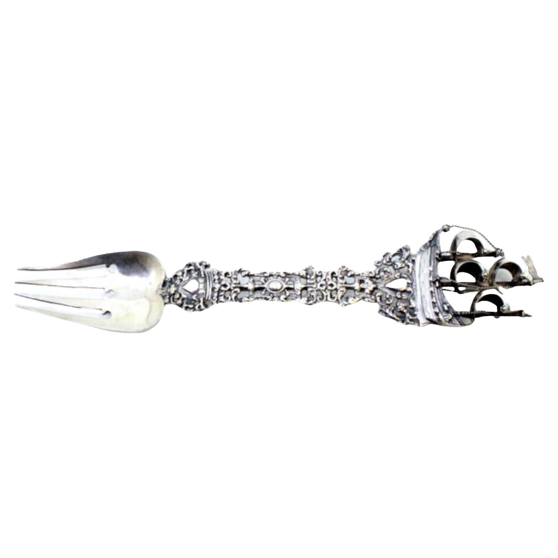 Decorative silver fork with cutouts, caravel and angels around monogram