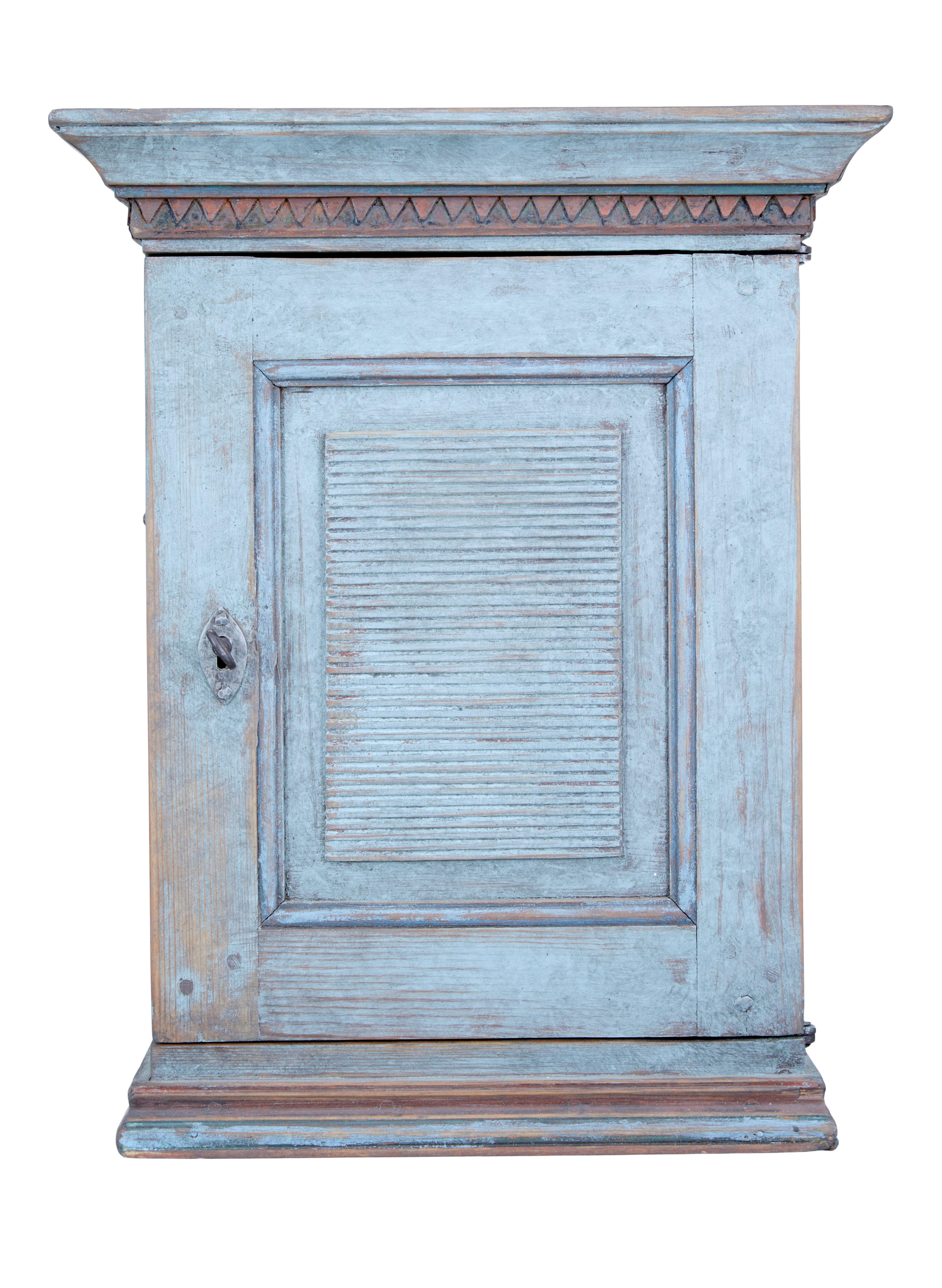 Decorative small 19th century Swedish pine wall cupboard circa 1870.

Here we offer a delightful wall cupboard with fitted interior. Cornice top with carved detail below. Single door with working lock and key complete with a fluted panel to the