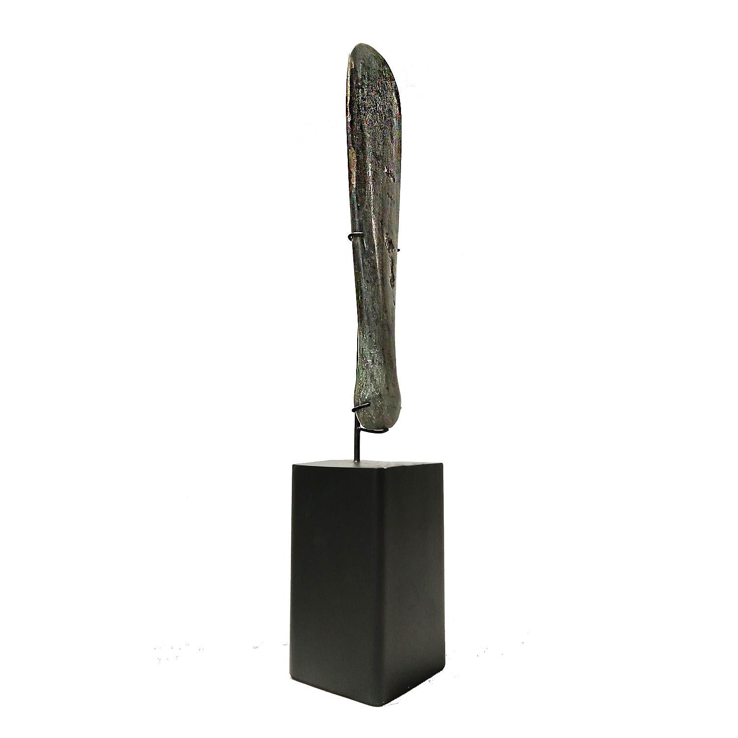 A hand-carved stone blade from Indonesia, mounted on a black stand. 

A small 