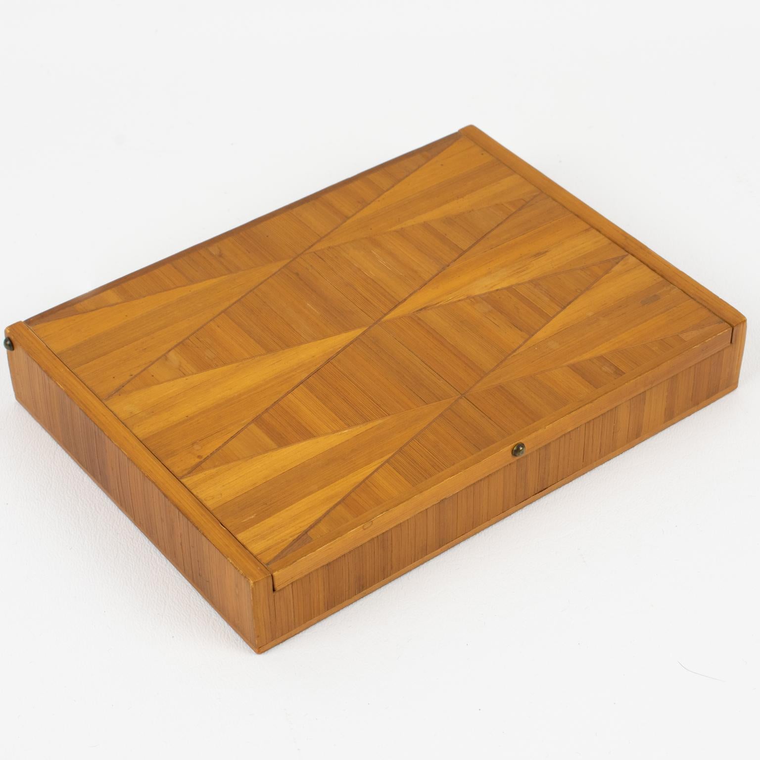 This elegant straw marquetry decorative lidded box has its design attributed to French designer Jean Michel Frank (1895 - 1941). The long rectangular shape has a refined geometric design, and the interior is lined with cork. There is no visible