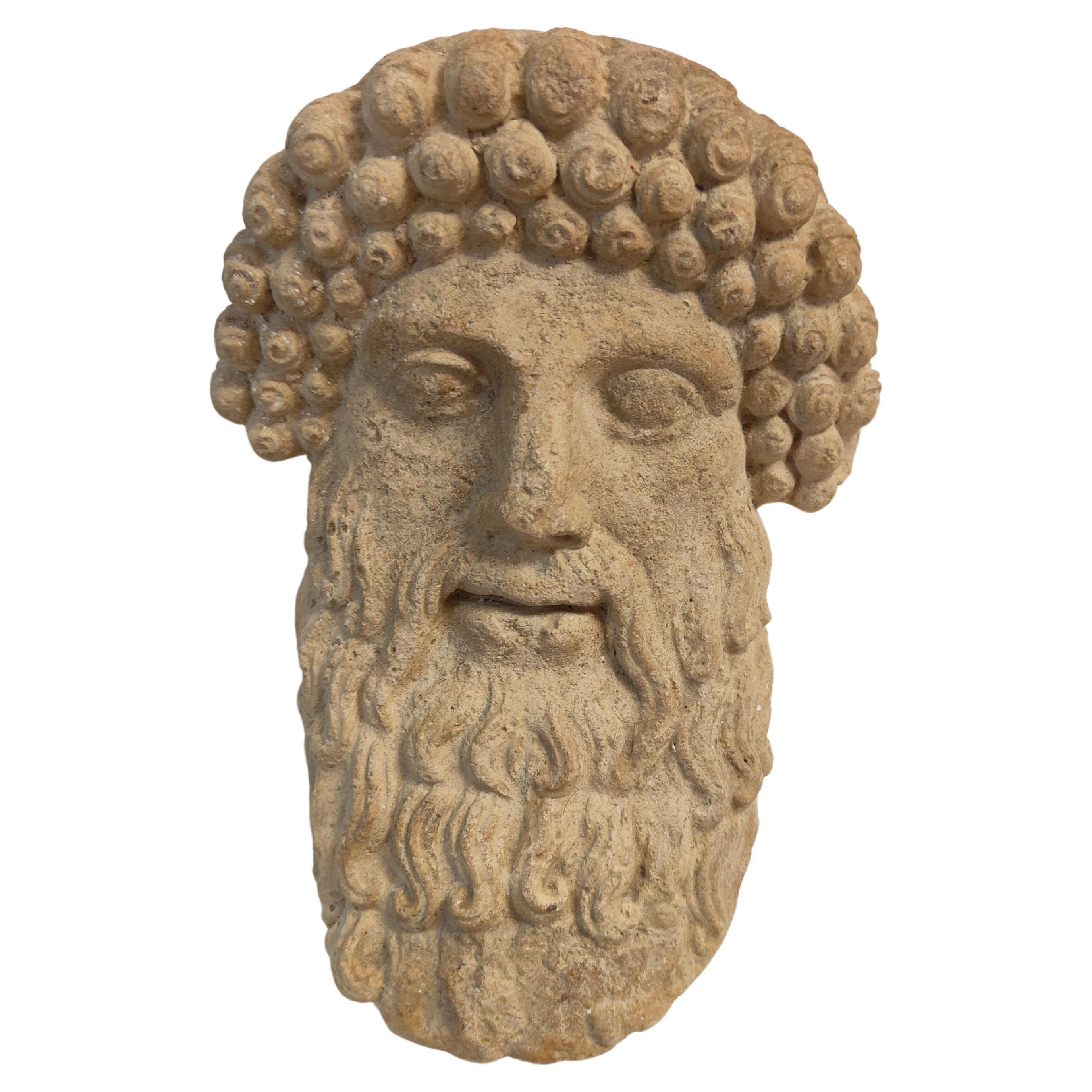 Tête décorative en terre cuite d'un dieu grec