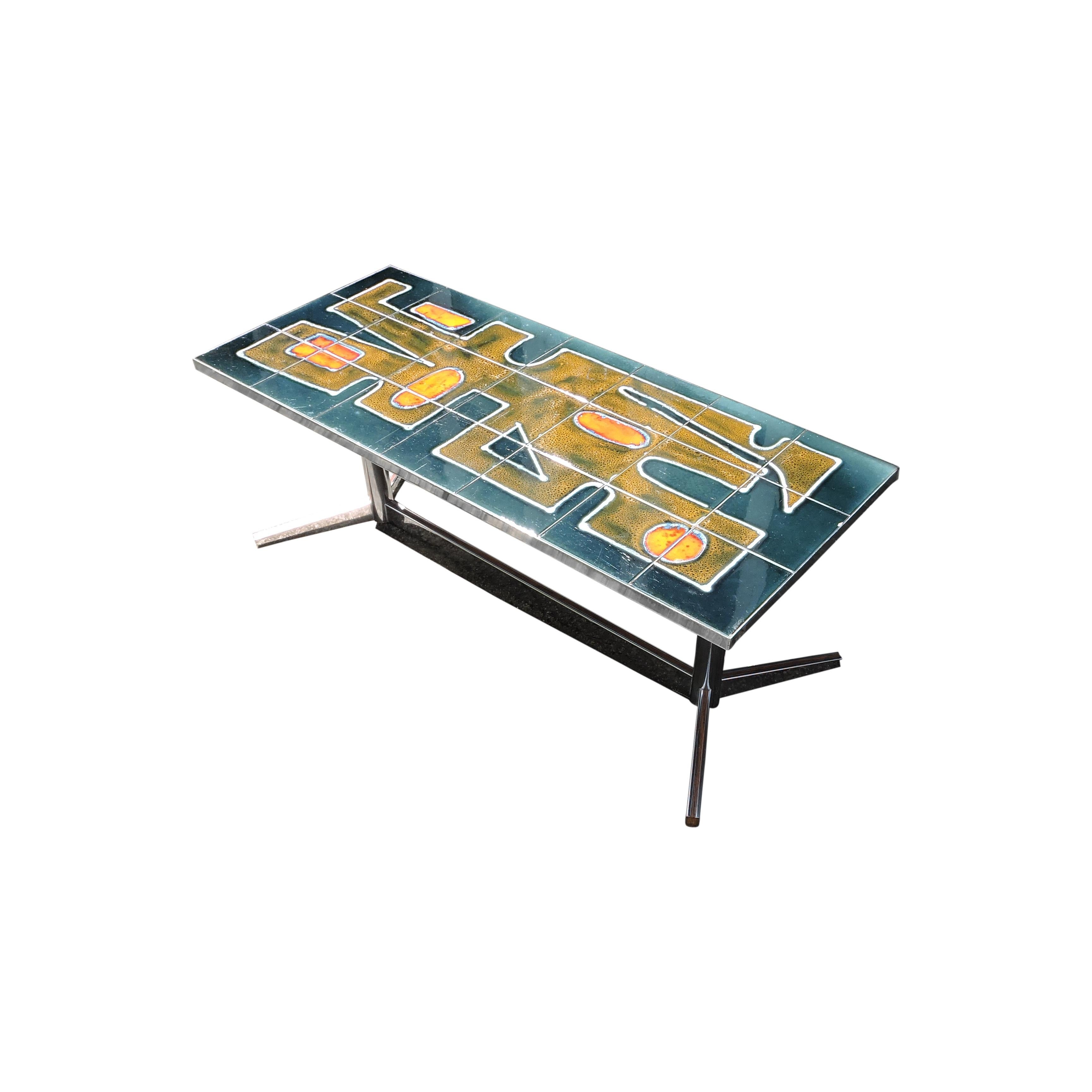 A tiled coffee table from the 1960s featuring glazed blue, green and orange tiles on a chrome table stand.