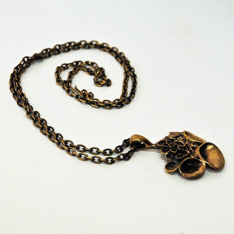 Beautiful bronze pendant with the popular Reindeer Moss look designed by Hannu Ikonen for Valo Koru, Finland 1970s. Naturally patina with dramatic relieffs of smaller and larger trumpet shaped decors. Good vintage condition.
Size of pendant: 4cmW x