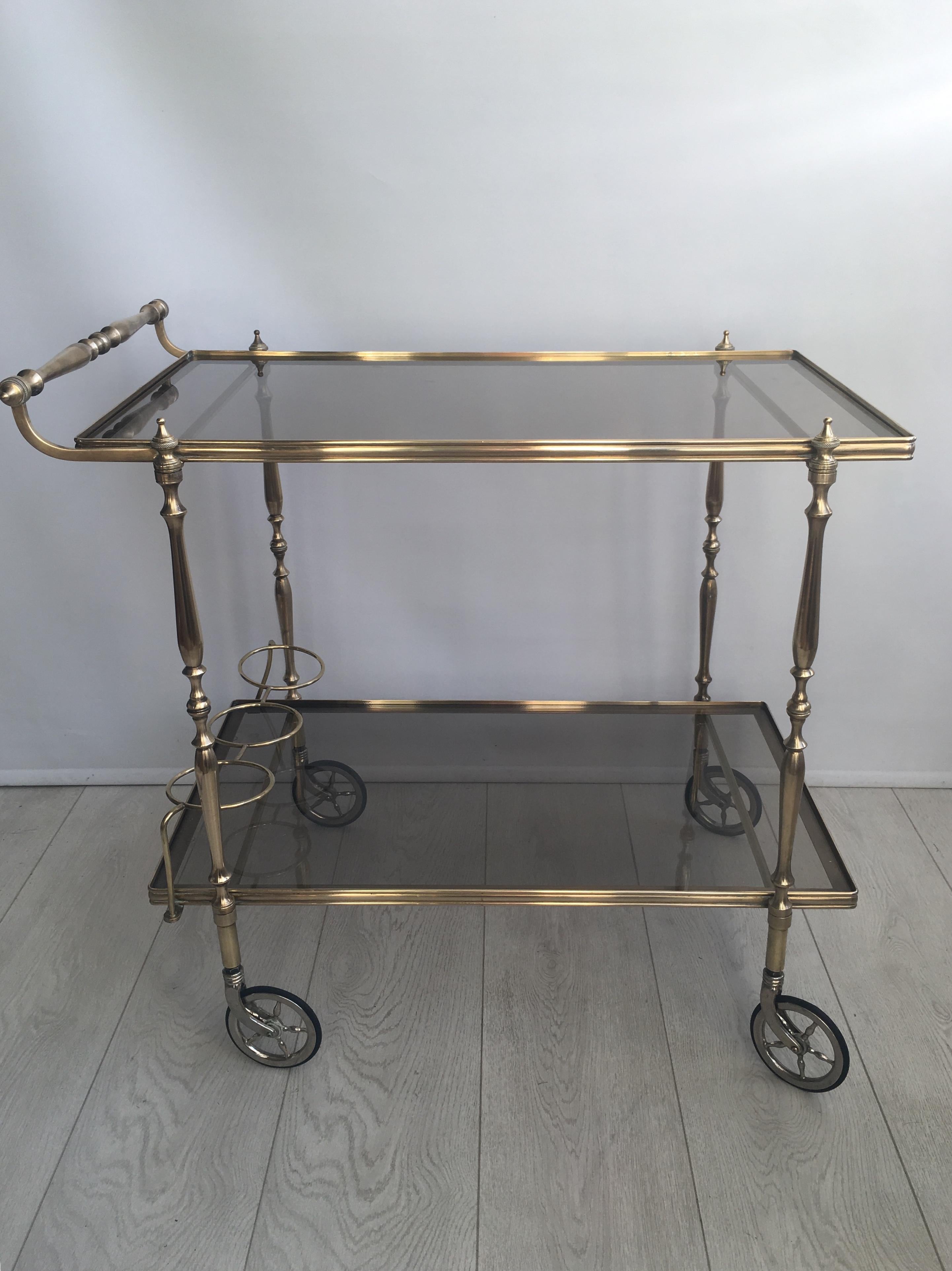 Great looking vintage drinks trolley from France, circa 1950

Some lovely detailing to the polished brass frame

Tinted glass shelves 

Top tray measures 68cm wide by 40cm deep and stands 63.5cm to glass
Overall dims 73.5cm wide, 44cm deep