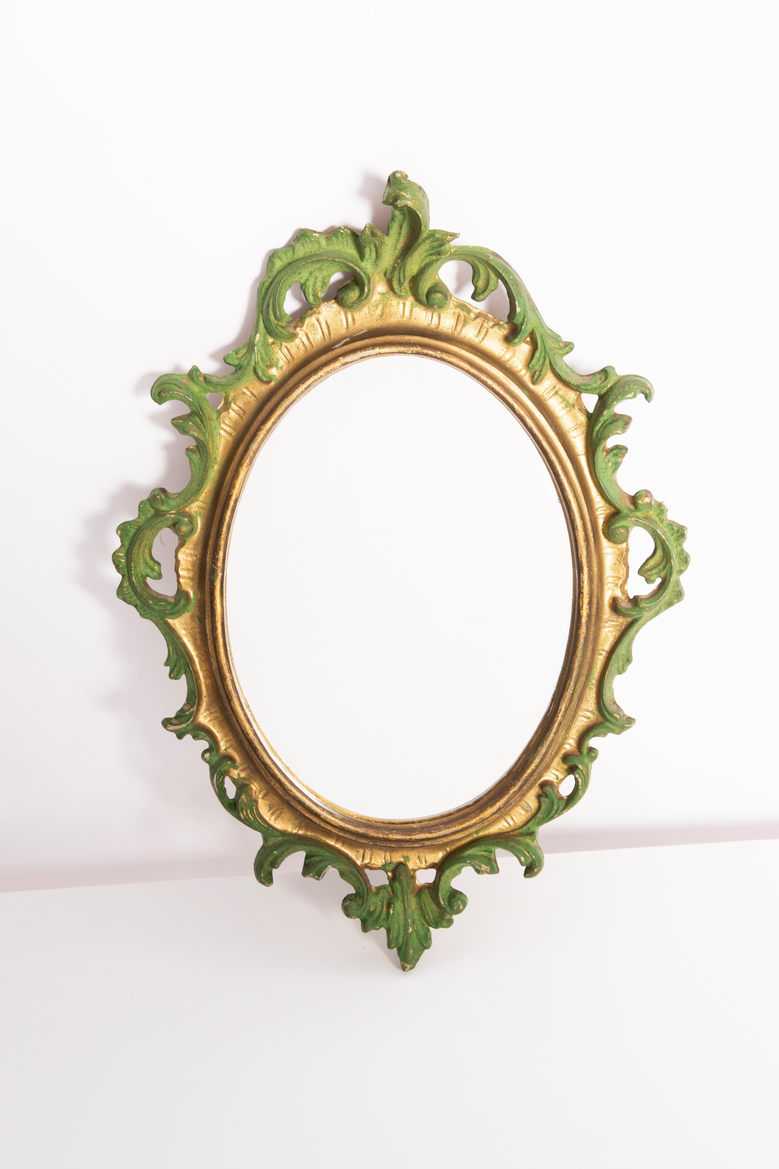 A beautiful small mirror in a golden decorative frame with flowers. Produced in 1960s in Europe / Italy. The frame is made of wood, painted in gold wood paint. Mirror is in very good vintage condition, no damage or cracks in the frame. Original
