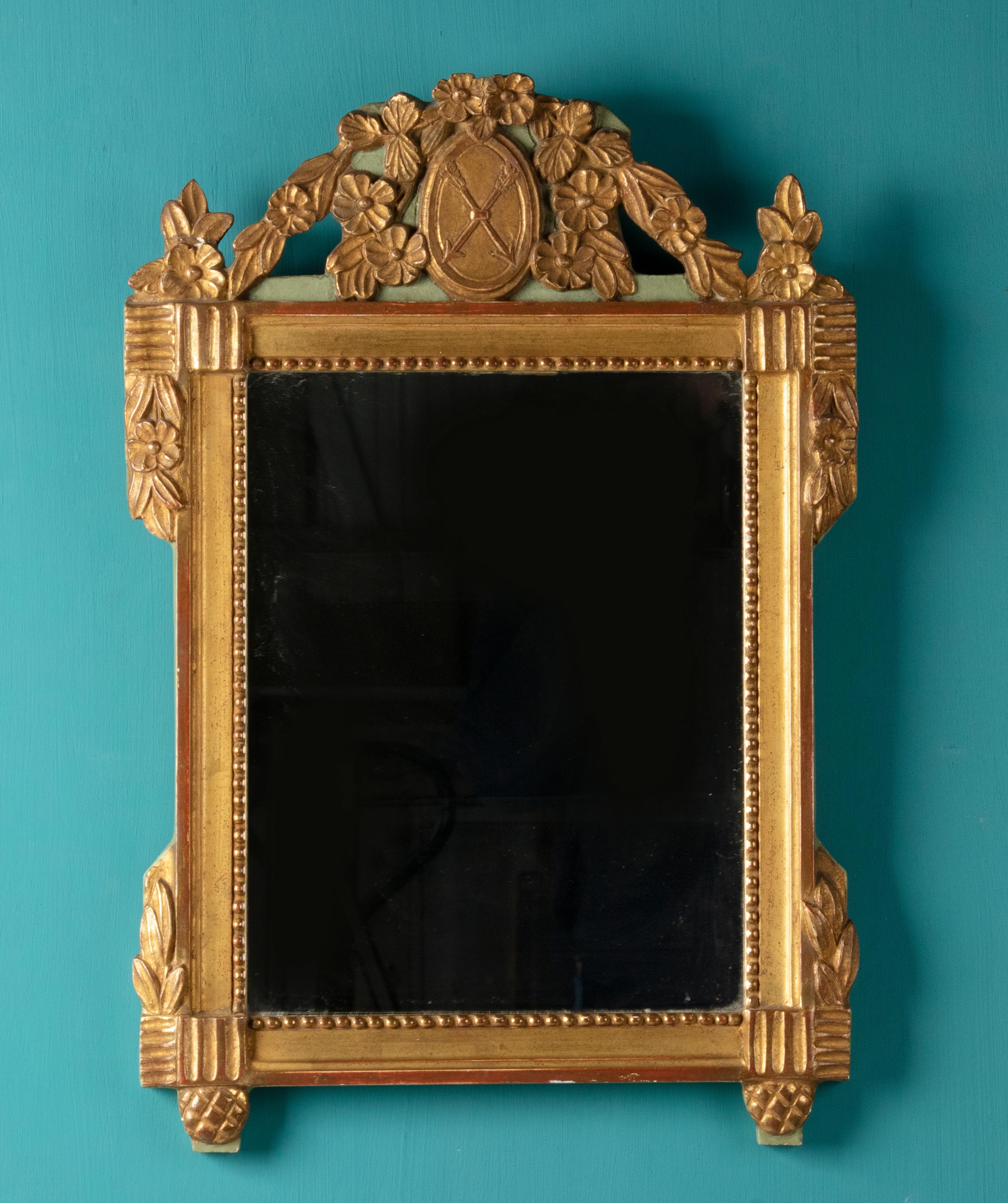 Miroir décoratif de style Louis XVI. Le miroir date d'environ 1930 et est fait d'une sorte de moulage en résine, puis doré. Le miroir est fabriqué d'après un modèle ancien.