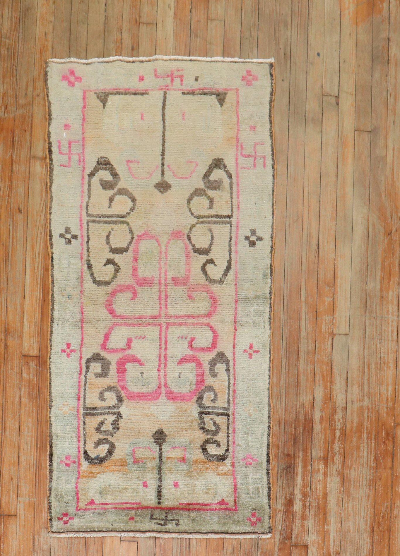 
2. Quartal des 20. Jahrhunderts Tibetischer Teppich in femininen Farben. Die Umrandung besteht aus weichen braunen, rosafarbenen und weißen Hakenkreuzen (卐 oder 卍) t religiösen und kulturellen 