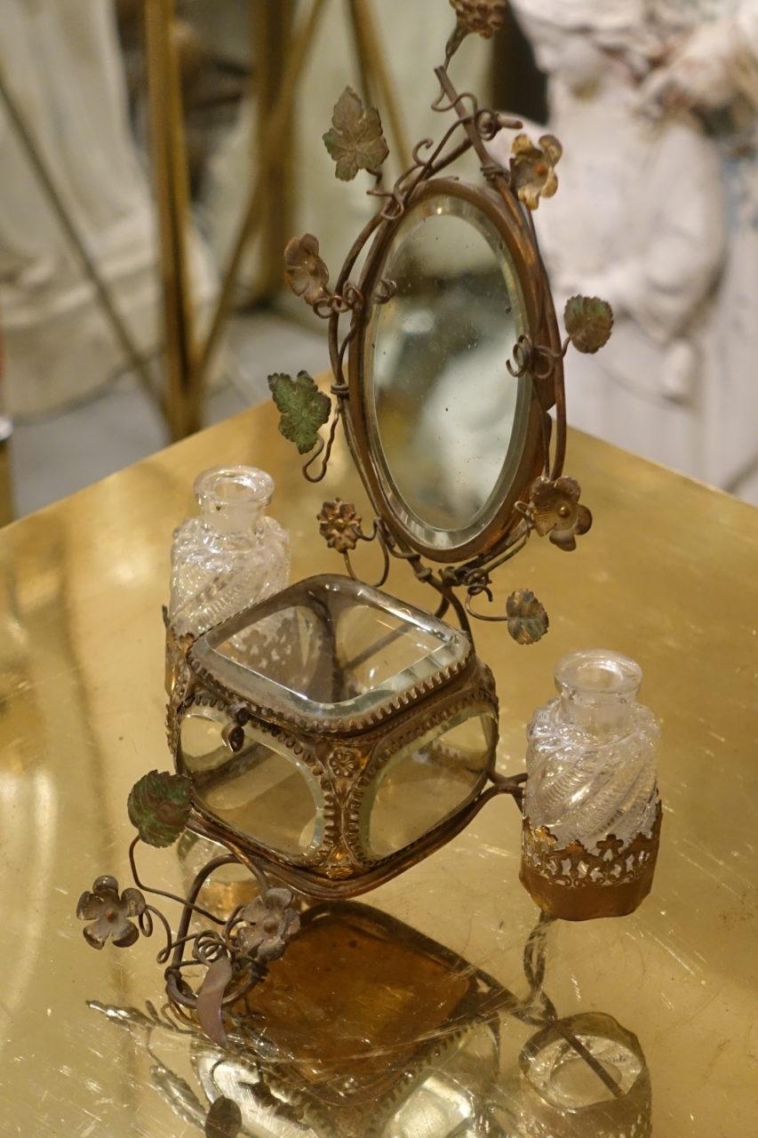 Fantastical and charming French raised glass trinket display case and scent holder, and with an artfully faceted glass case and lid, and crystal glass sides. Attached to the case, a gorgeous small oval mirror, decorated with small painted floral and