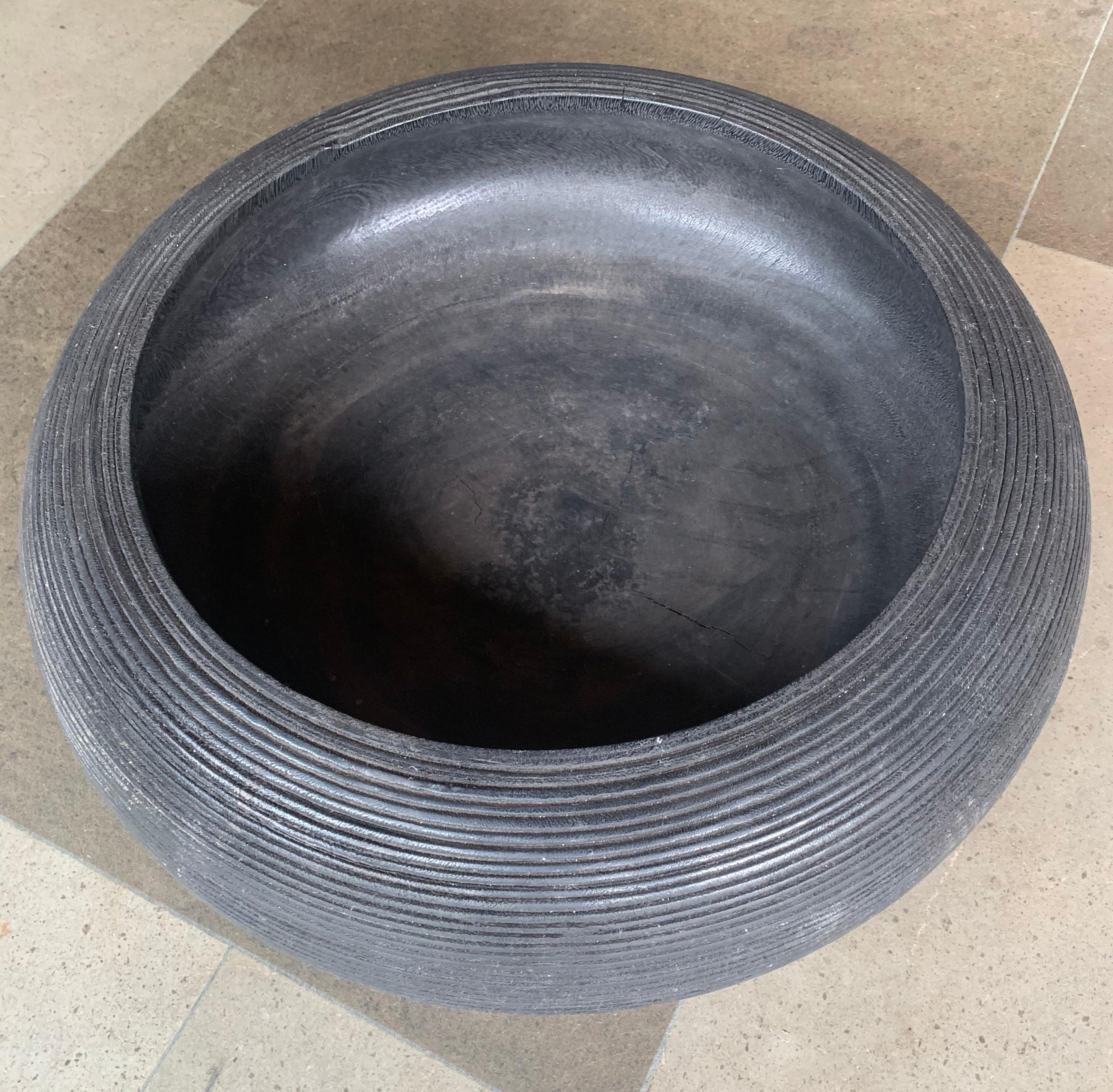 This wooden bowl features a black lacquer finish and ribbed pattern design on its exterior. It is crafted from Suar Wood and was made in Indonesia. Its simple design makes it a great decorative addition to any space. 

Dimensions: Height 17cm x