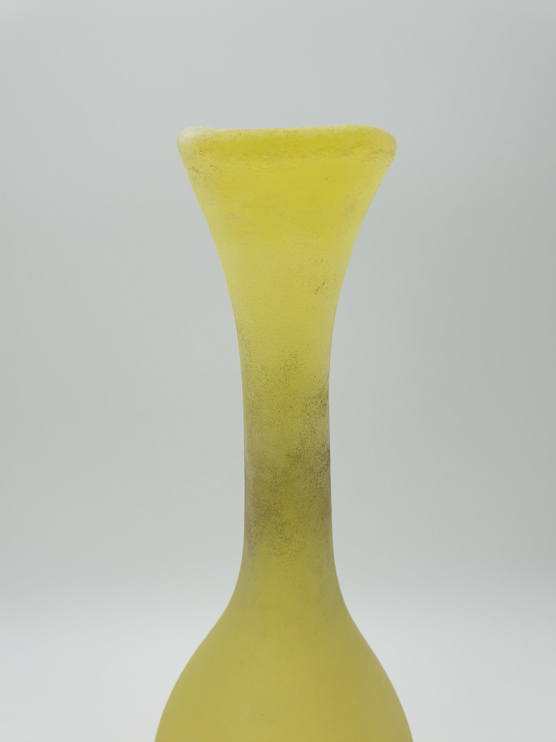 A bright yellow “scavo” glass bottle by Gino Cenedese e Filgio. This piece features the “scavo” finish that made Cenedese famous and still distinguishes the company production among glass producers. 