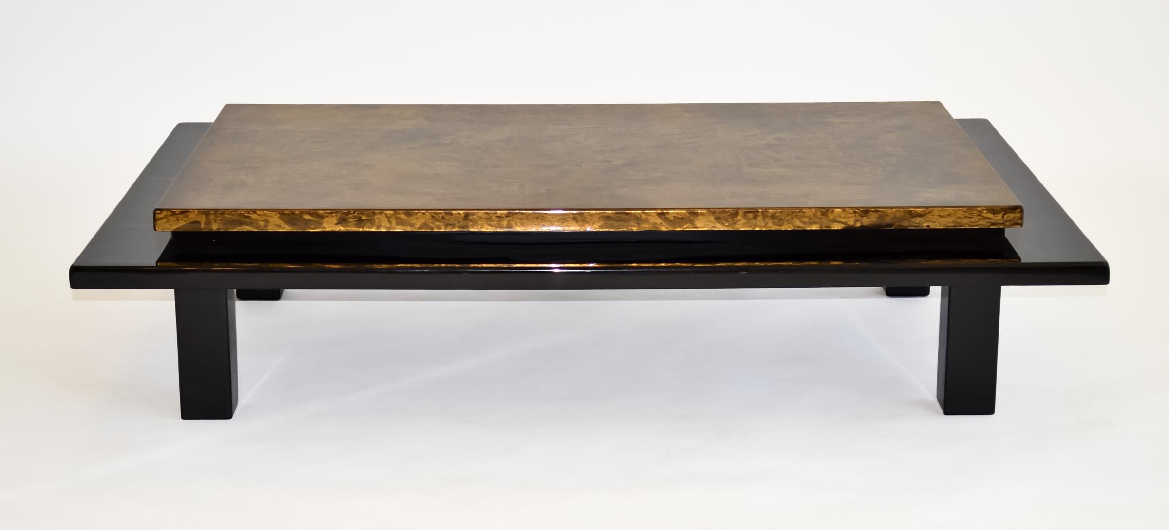 Decorator Black Lacquered Coffee Table Faux Gold Finish Asian James Mont 1980s
Rectangular low cocktail table. Gorgeous mirror-like lacquered black base and columnar legs supports a floating, deep gold faux painted surface. Thick, shiny epoxy