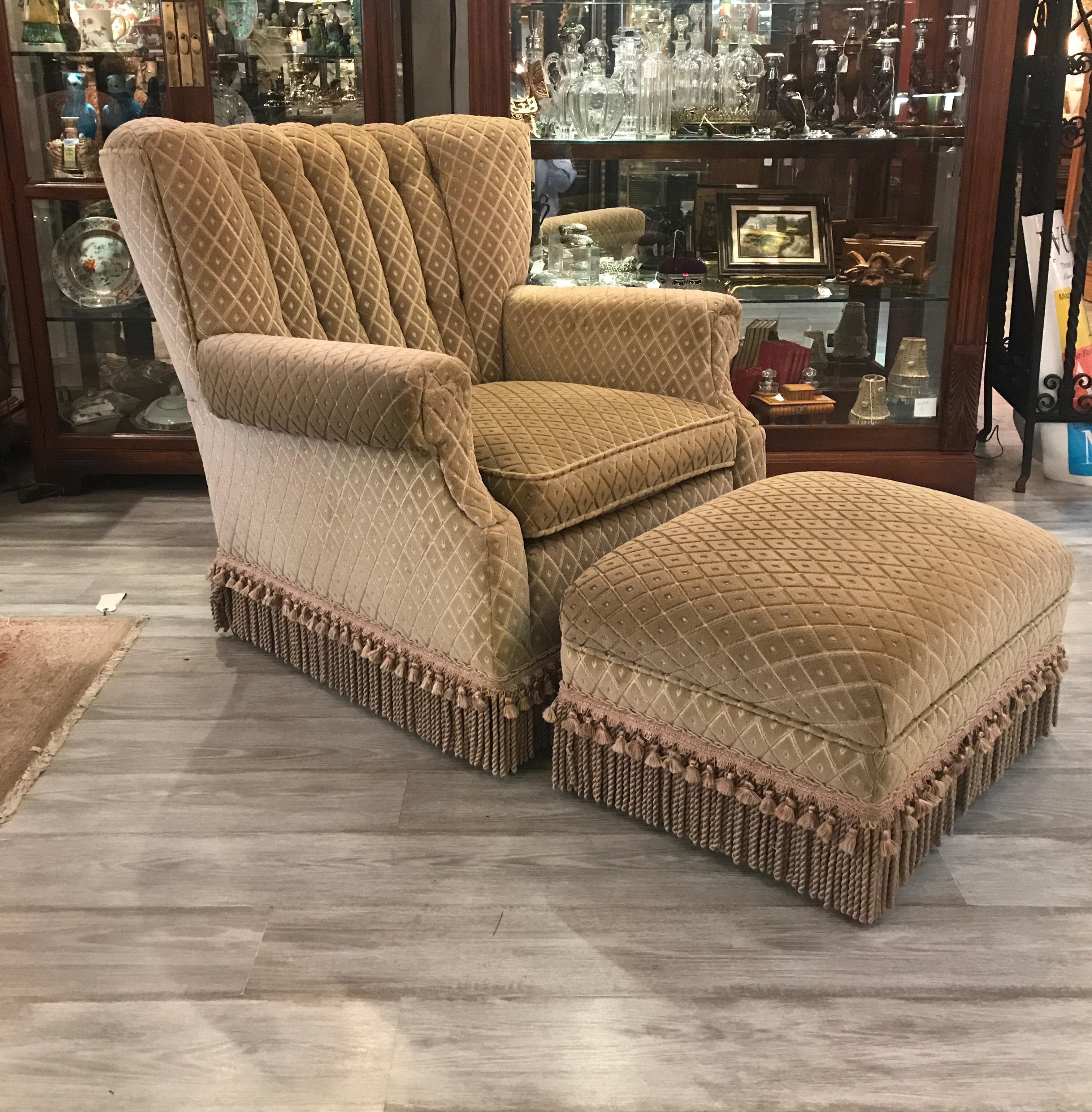 Stylish upholstered chair and ottoman in cut velvet with bouillon fringe. The chair with an 8 way hand tied spring construction and kiln dried hardwood frame made by Swaim. This Art Deco 1940's style the channeled back with a gentle cure for