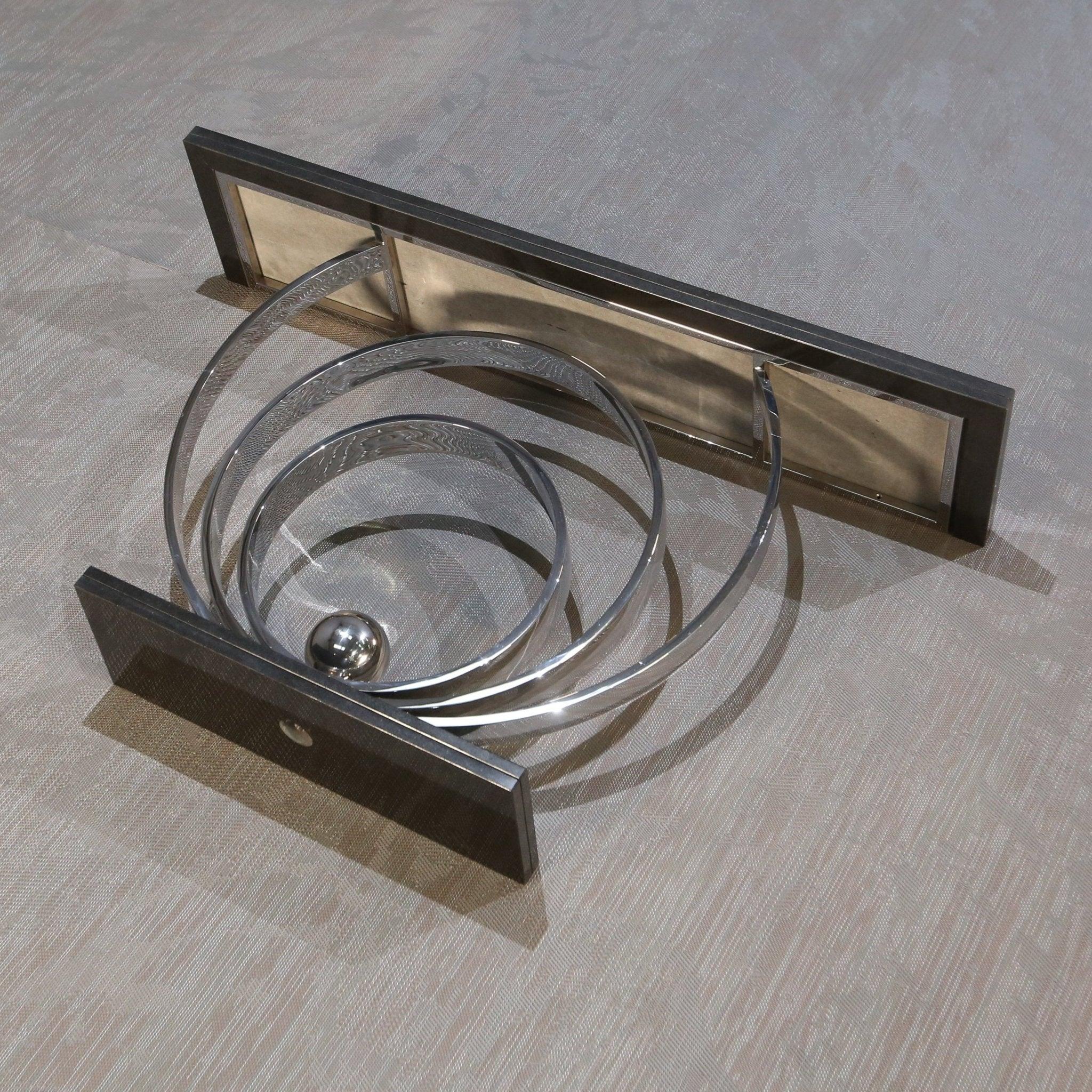 Esta consola Ammonite de Decorus, fabricada en 2017, tiene una base de acero inoxidable pulido y una encimera de granito negro. Su diseño moderno la hace perfecta para espacios de vida contemporáneos. Ideal para añadir un toque de elegancia a tu