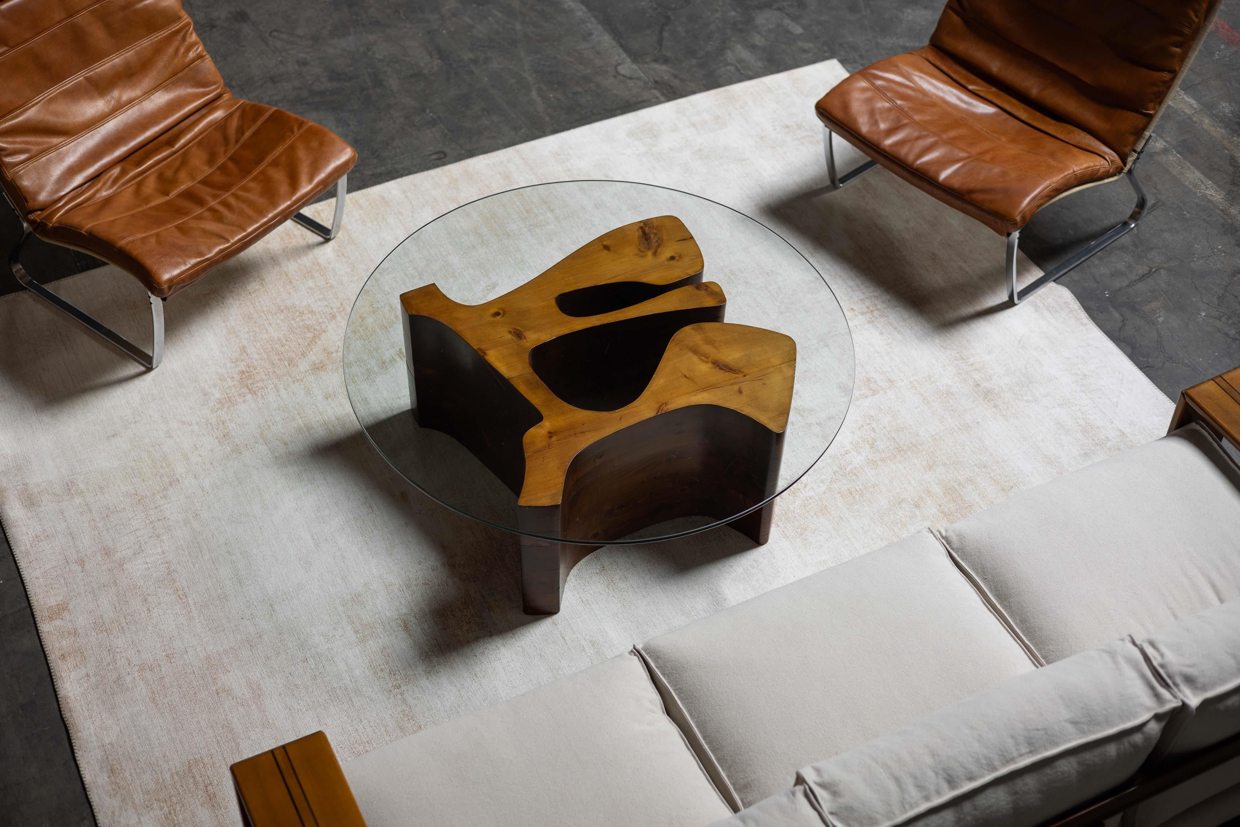 Esta singular mesa de centro esculpida, diseñada y creada por el artista Dedalo Montali en Italia durante la década de 1970, es una sorprendente pieza de arte funcional. La mesa tiene una base de madera de pino maciza con una forma bellamente