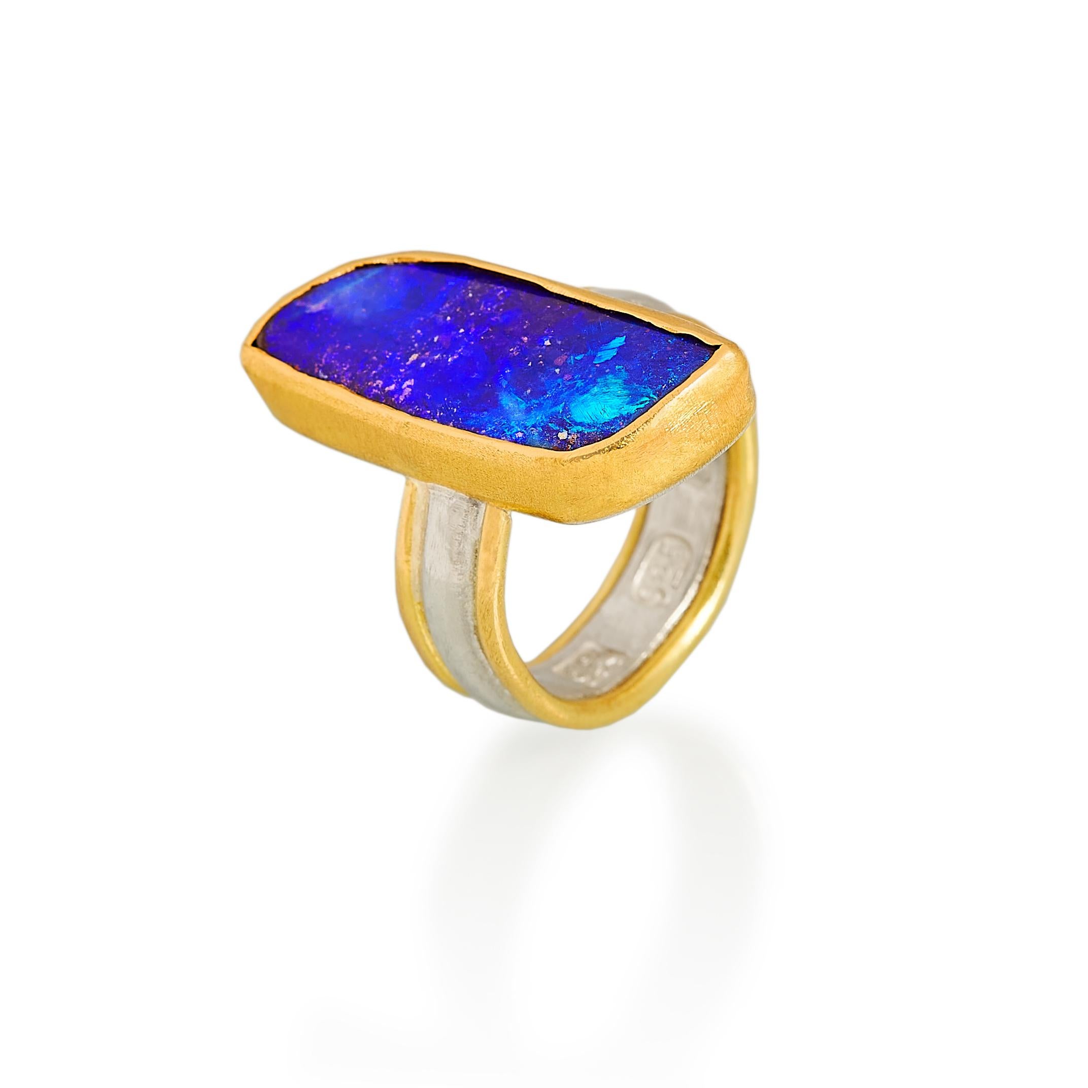 This vivid deep blue boulder opal is complimented in a 22 karat textured yellow gold setting. The shank is silver with 18 karat gold and it has large distinct British hallmarks. 

U.S ring size: 7¾
U.K size: P

Please don't hesitate to contact us if