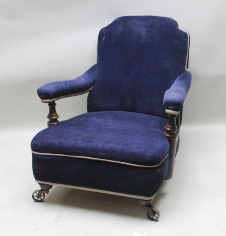 A very comfortable low 19th century English open arm fireside club chair. Upholstered in old deep blue fabric with white trim. Seasoned hardwood frame with finely turned mahogany arm supports, sloped back with shaped top and notched corners, deep