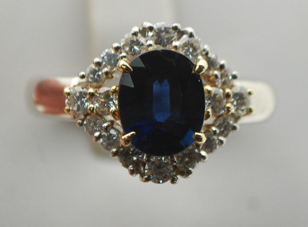 Luxurious engagement ring or a cocktail ring made in platinum and 18KT yellow gold. The center is a stunning dark blue sapphire with enough light to show that blue color, the diamonds are fine quality VS clarity and F color. Ring is size 7 and can