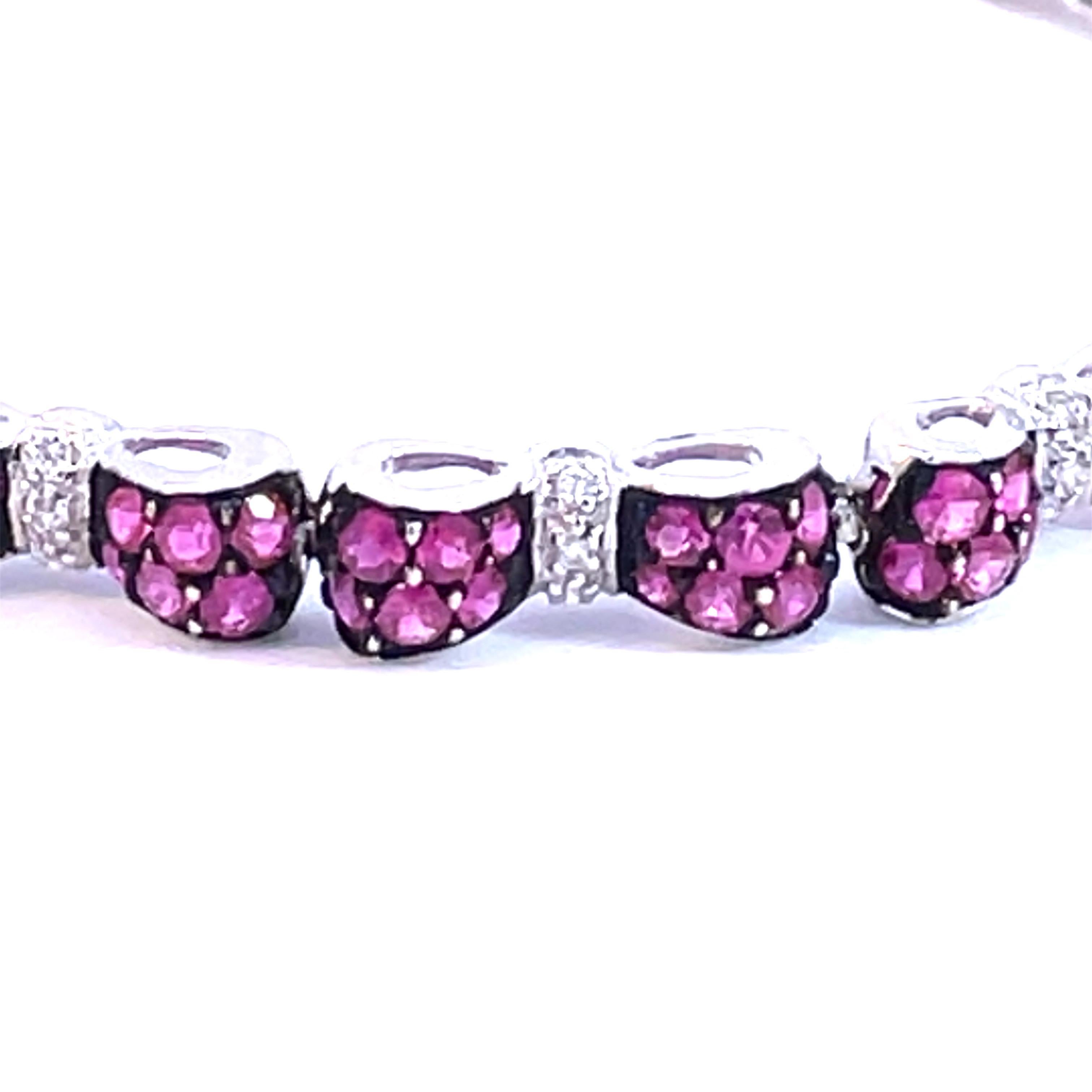 An Beautiful Bow Tie Bracelet set with natural pink sapphires and natural white diamonds with a black rhodium finish around the deep pink sapphires in 18kt white gold. 

144 natural deep pink sapphires weighing 6.00ct total weight

36 natural white