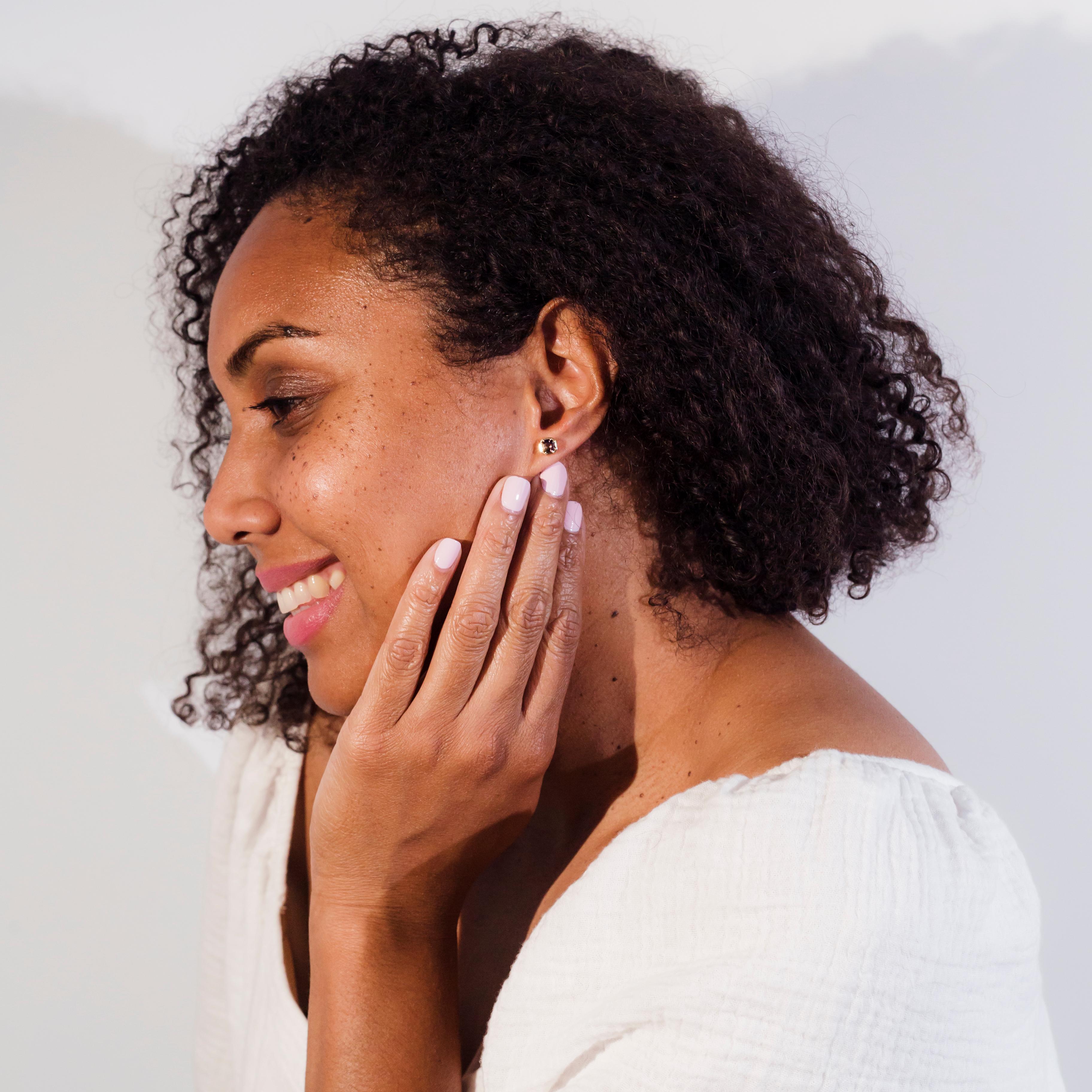 Crafted in 9 carat yellow gold, these alluring contemporary stud style earrings each feature a wondrous deep pink Asscher cut spinel sitting in a gorgeous tapered bezel setting. We named these petite studs The Juna Earrings. They fit comfortably to