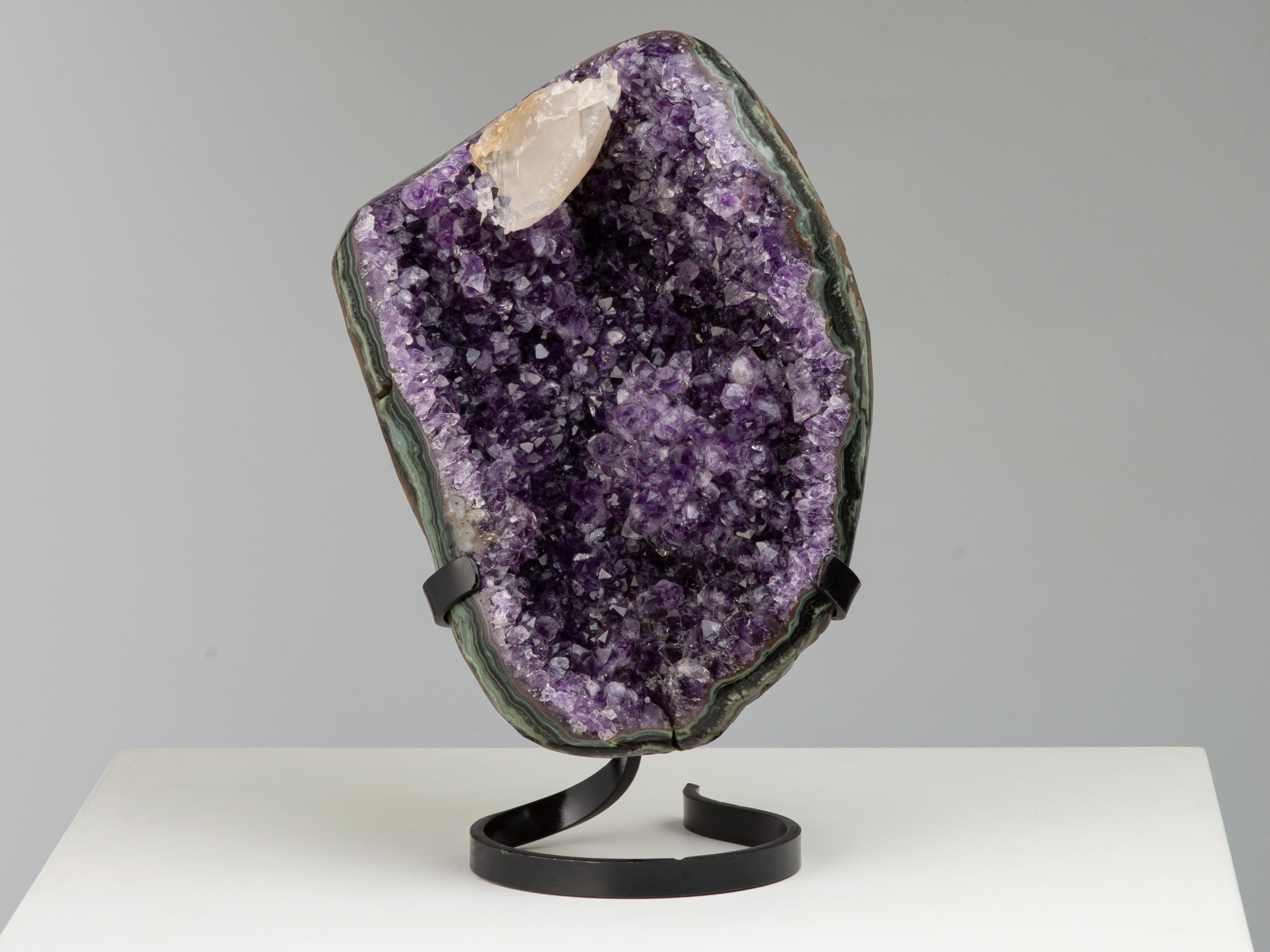 An interesting and stunning amethyst cluster with a striking mineral and colour mix. 

In this aesthetic piece the edges have been polished to reveal layers of a vibrant green celadonite, blue-grey agate and white quartz, which frame the intense