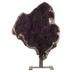 Objeto decorativo de geoda de amatista de color púrpura intenso, con una grieta dinámica y de gran tamaño