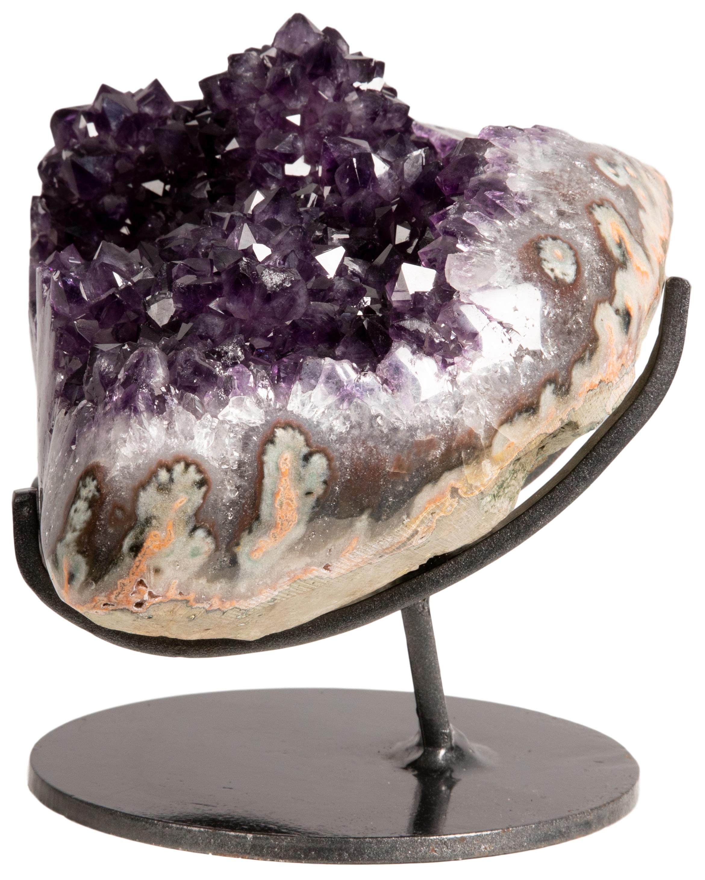This piece comprises a stunning example of deep purple amethyst, elegantly displayed on a metal stand, with a naturally decorative multiple stalactite formation. 

The polished borders of the formation allow one to appreciate the visible grey and