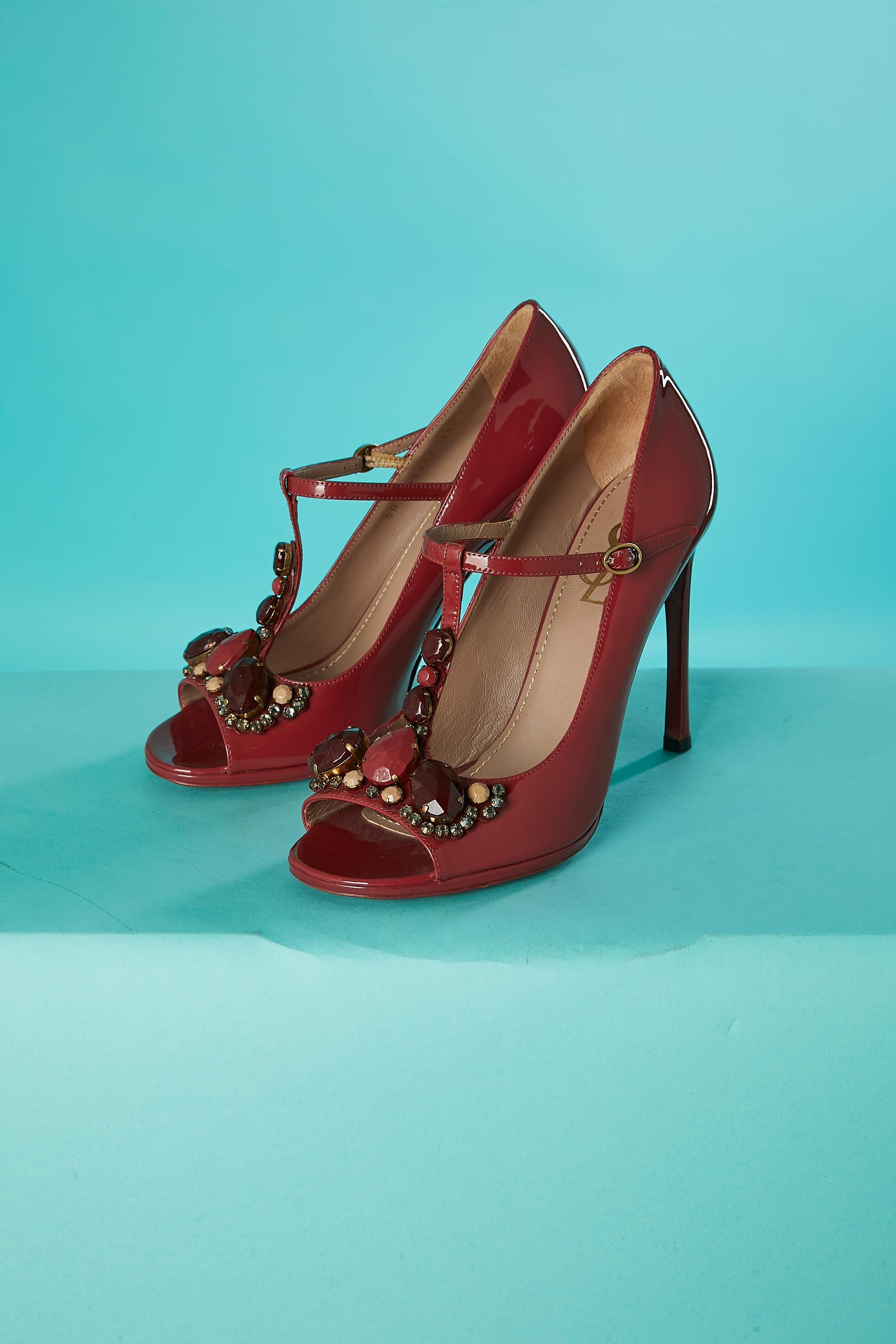 Deep red patent leather open-toe sandals with cabochons and rhinestone. Buckle closure on the top side. 
 heels height = 11 cm
 plateform = 1 cm
SHOE-SIZE = 38 1/2 
