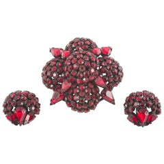 La pâte de rubis profond « circulaire » est de type  Broche et boucles d'oreilles Warner, États-Unis, années 1950