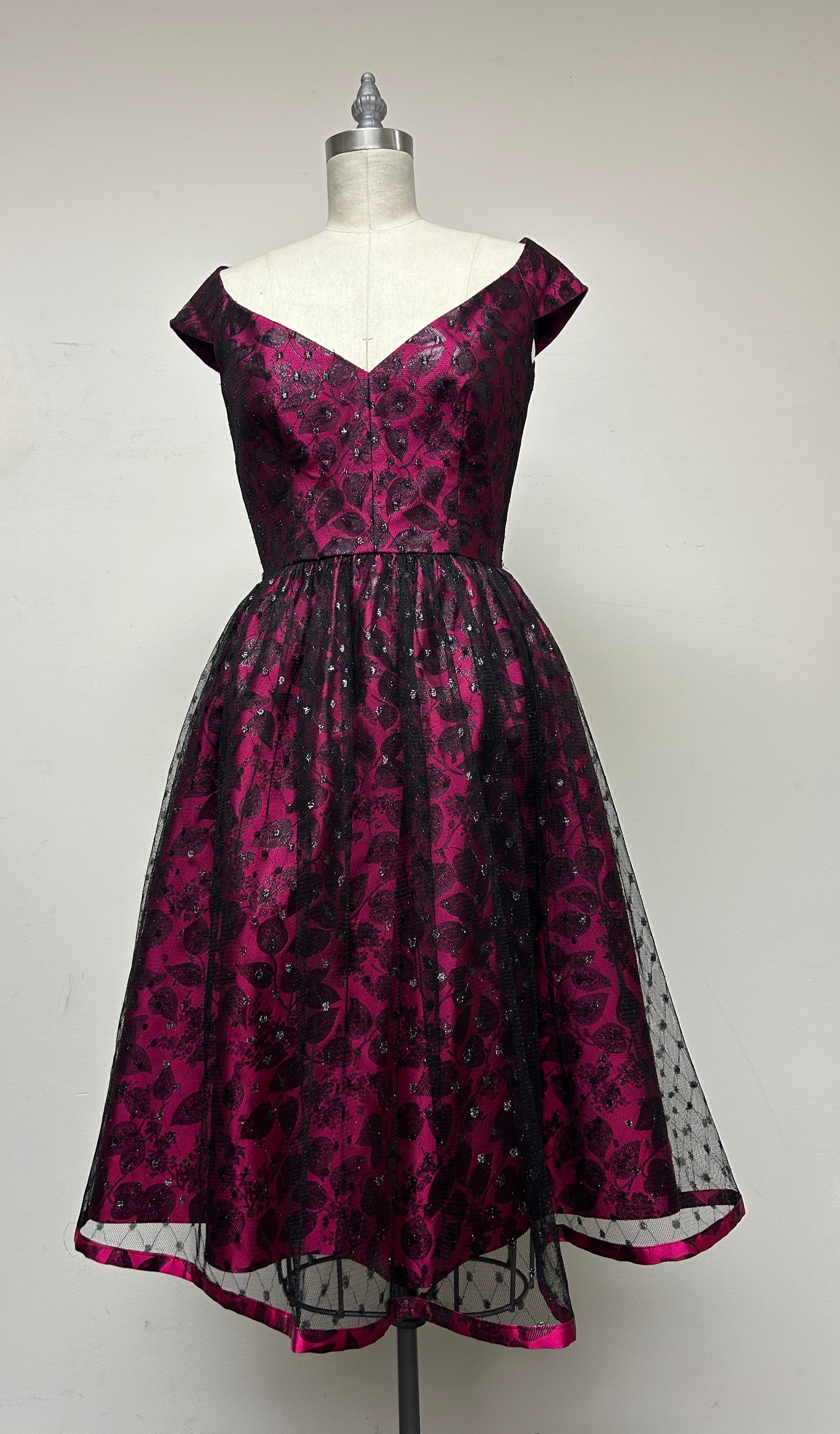 The prettiest party dress in Fuchsia brocade and overlayed with sparkly black point d'esprit that covers the entire skirt, making for a magical, textured quality. The lace is trimmed with brocade at the bottom of the point d'sprit, giving a charming