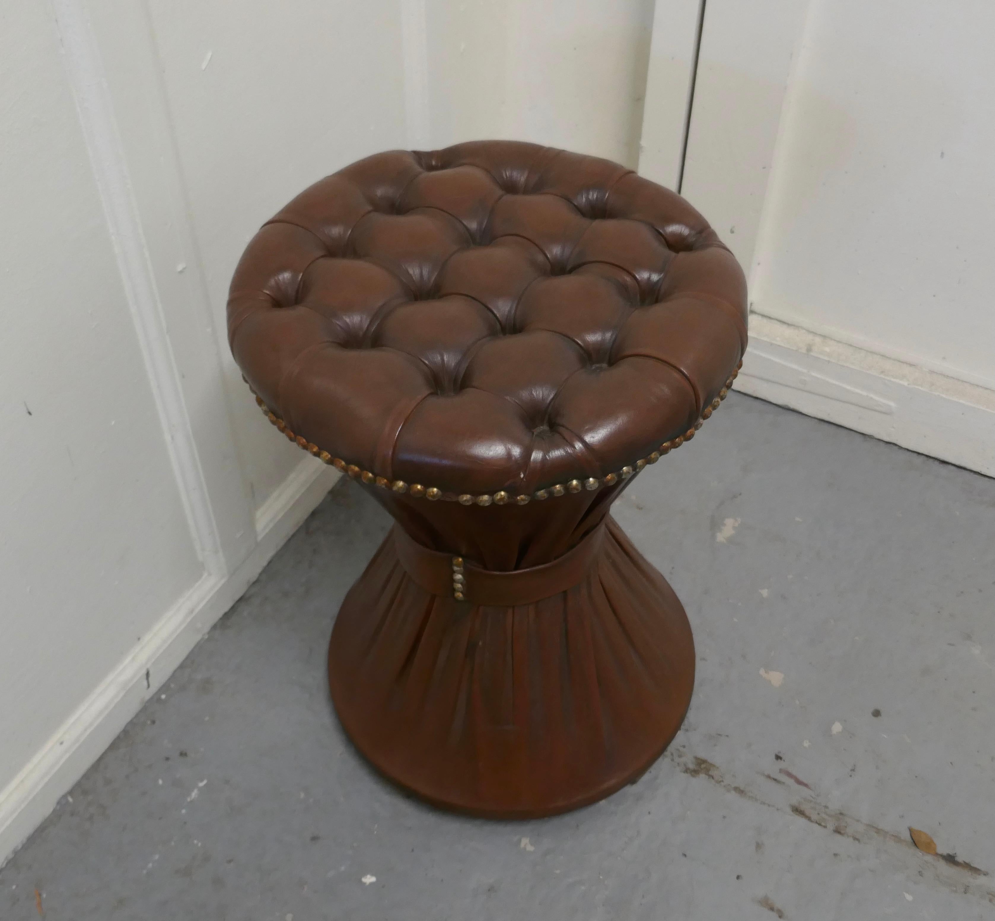 Deeply Buttoned Tam Tam leather stool 

This is a good Sturdy stool it has a deeply buttoned top and the leather is gathered at the mid point of the base forming the classic Tam Tam shape

The stool is upholstered in a brown Leather with brass