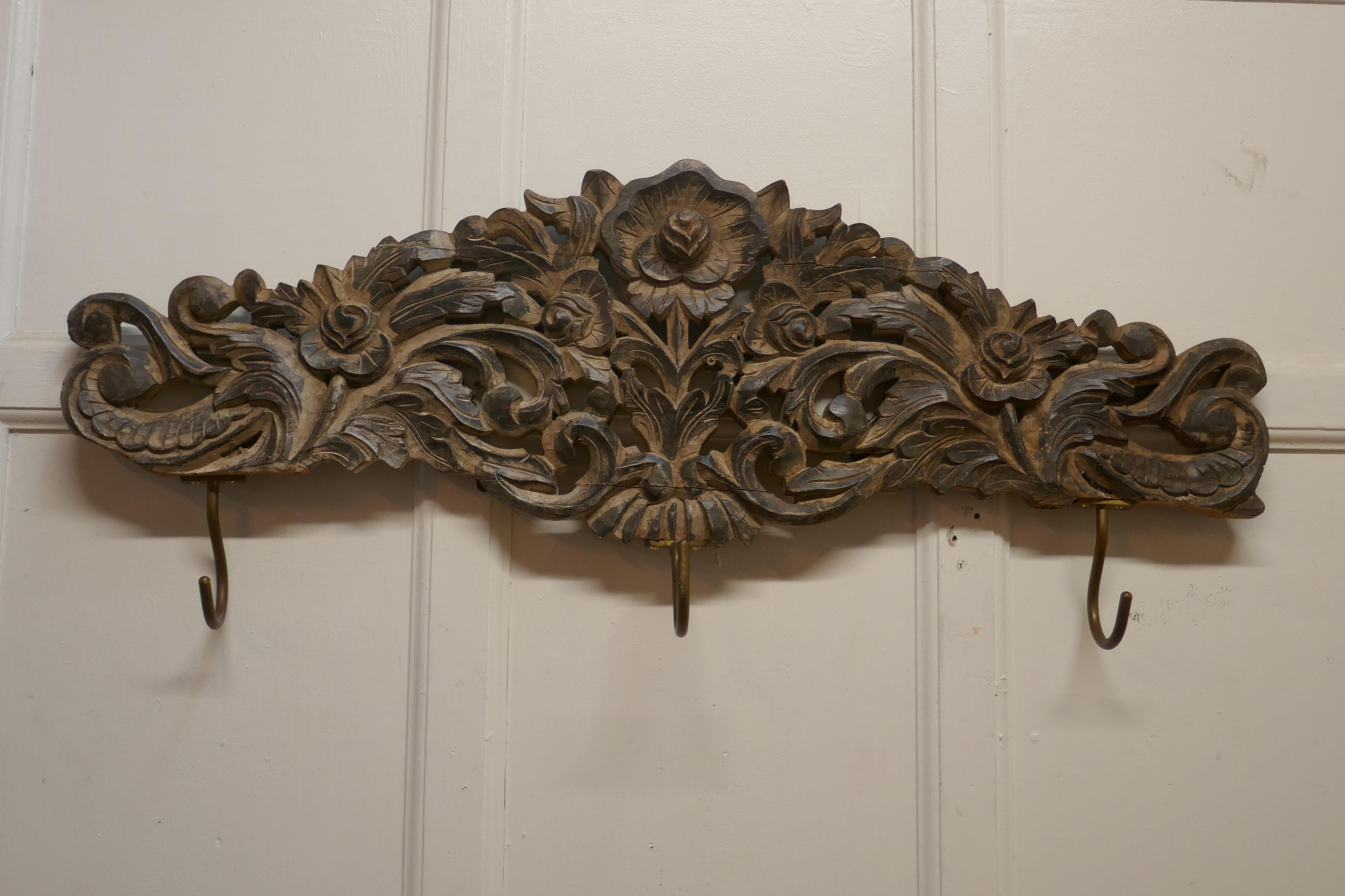 Deeply carved hat and coat hooks rack

This is a solid piece, carved with Flowers and Leaves, it has 3 oversized brass hooks at the bottom. 
The rack is 6” deep, 40” long and 17” high
AC281.