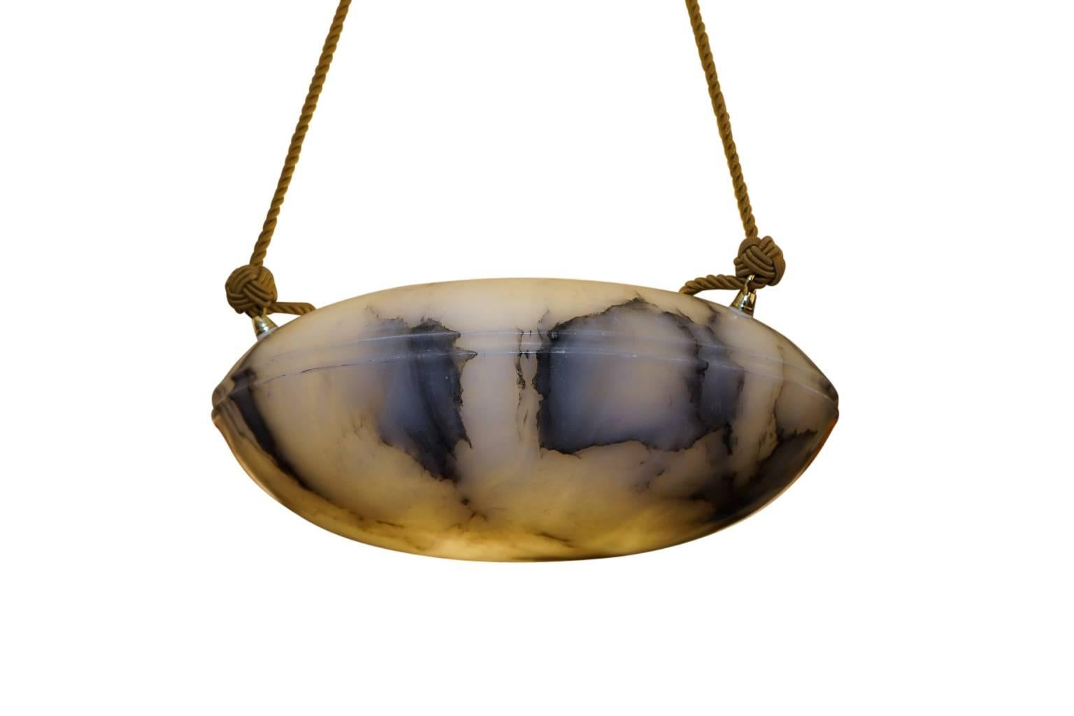 Dramatic and cooly resembling a flying saucer, this elliptically shaped light fixture strikes a serious, and defined mood. The charcoal mineral veining sets the tone, while the tight double banding in the center reflects the constraint of the