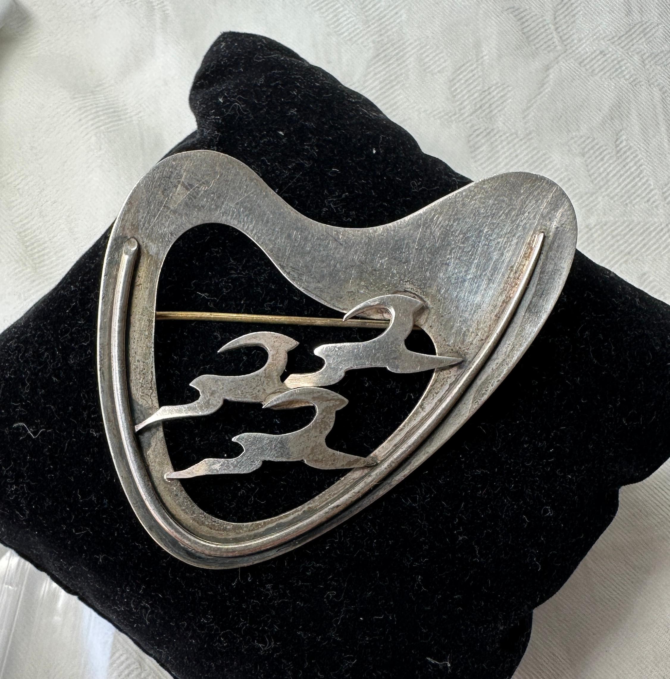 This is a wonderful and rare Denmark Sterling Silver Three Running Deer or Antelope Mid-Century Modernist Brooch. 
The brooch is fully hallmarked with a maker's mark, Sterling, Denmark and haandarbejde (hand made in Danish).  The modernist brooch