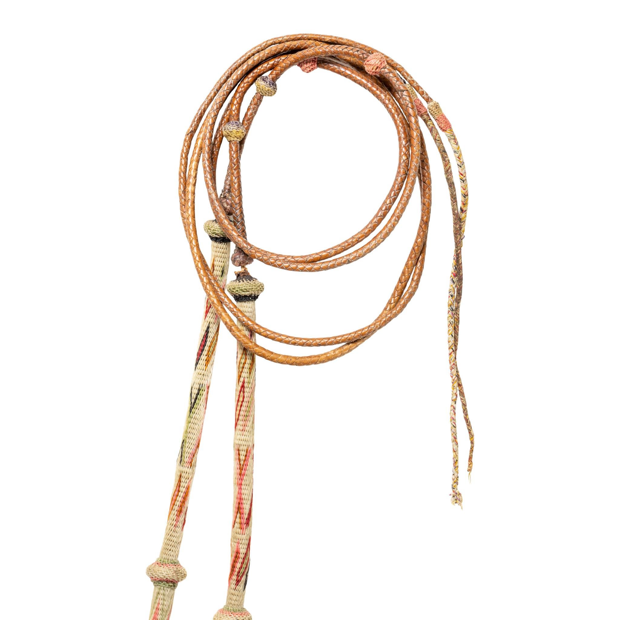 Multicolored Deer lodge Prison horsehair bridle with double round cheekbands, flat brow and nose bands. Glass horse head rosettes on top, running dogs on bottom, both encircled in horsehair. Five round headbands tied together with kangaroo leather