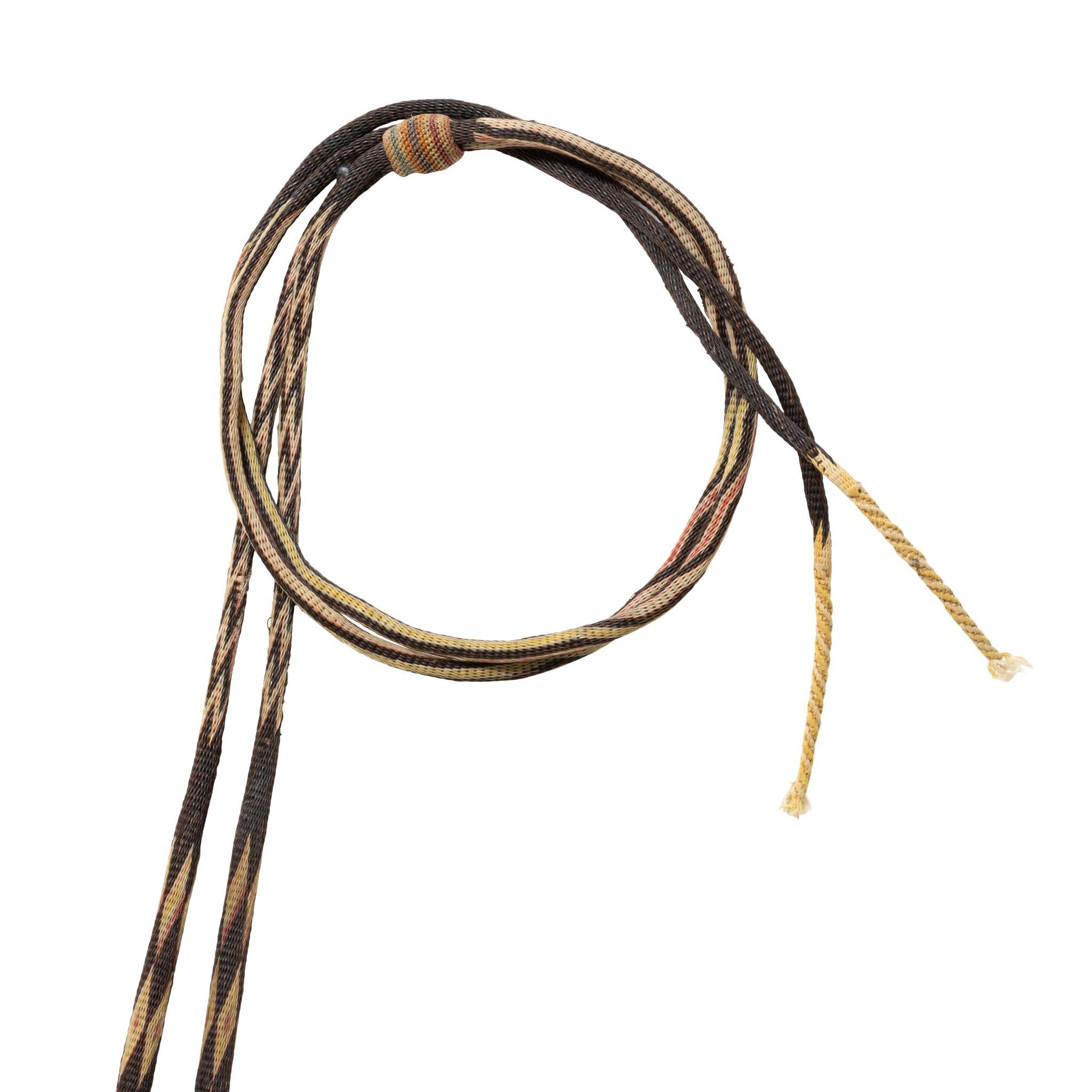 Deer Lodge Prison Horsehair bridle. Multi-colored with flat cheek, brow, and nose bands. Four candy-striped headbands attached with kangaroo leather and celluloid ring, tassels and knots. Glass stag rosettes on browband, dog heads on noseband,