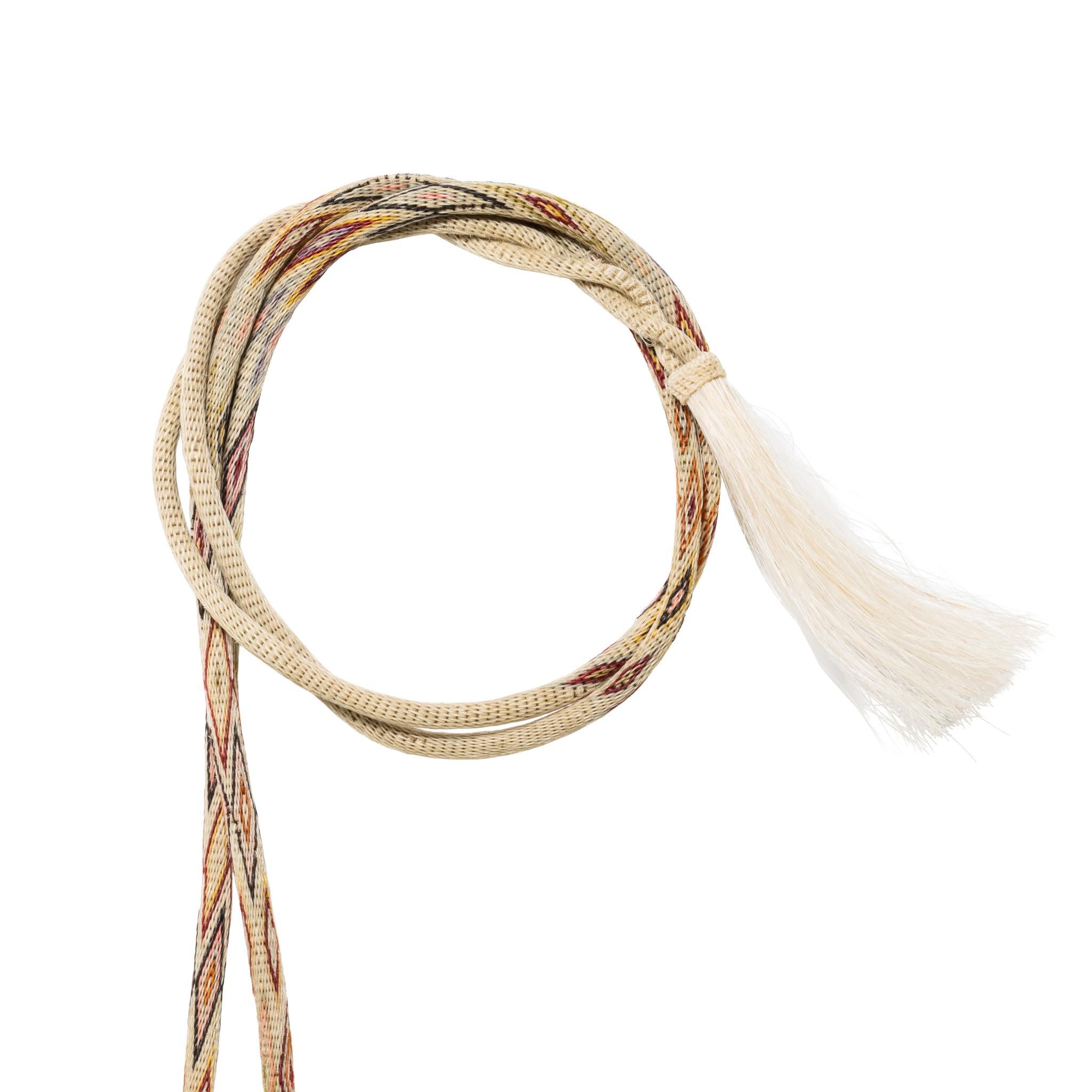White multi-colored Deer Lodge Prison horsehair bridle. Glass running horse rosettes on browband and running dogs on noseband encircled in horsehair. Five candy-striped round headbands attached with kangaroo leather and celluloid ring. Nondescript