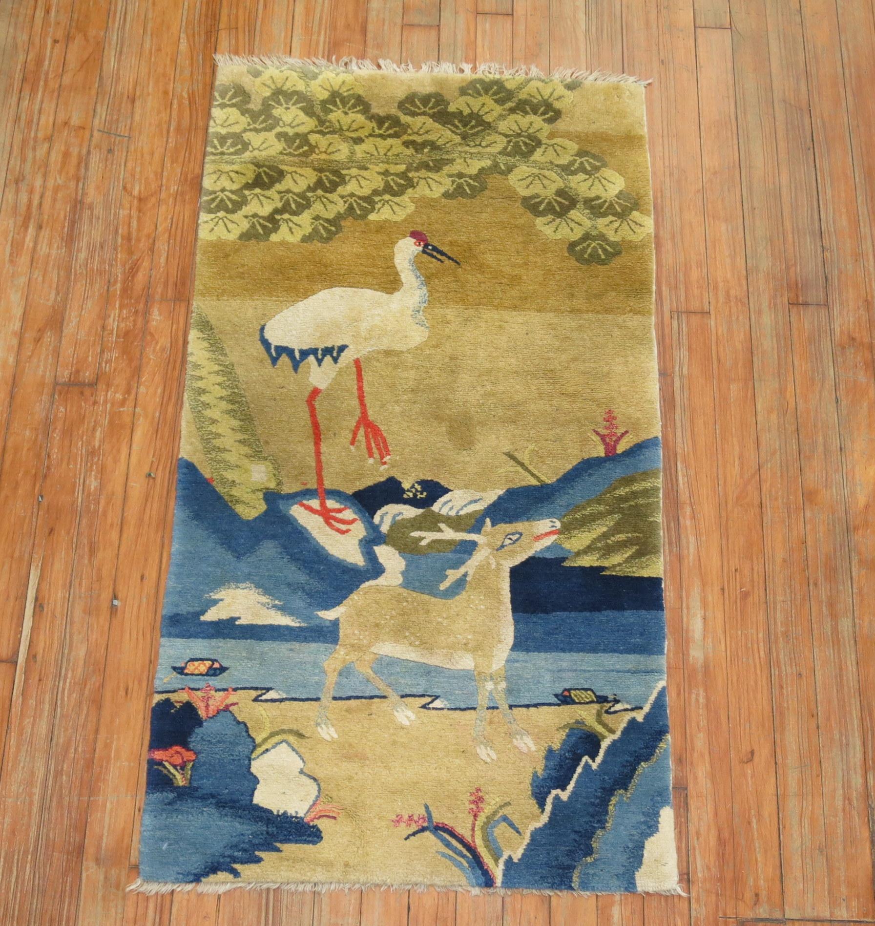 A fine quality antique Tibetan throw size rug depicting a baby deer and swan with a scenic landscape in light blue, camel, brown and ivory accents.

Measures: 2'2