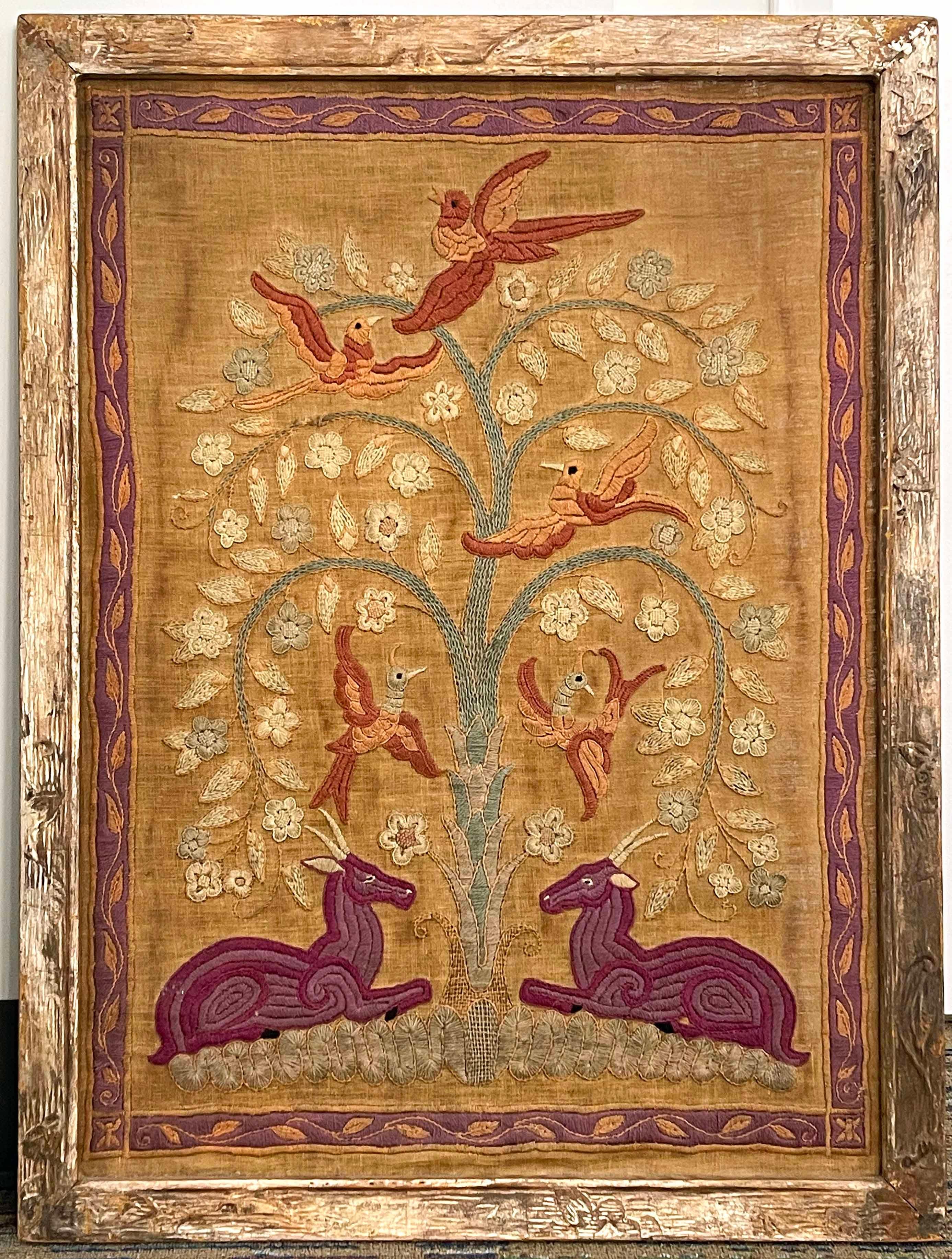 An important example of Modernist needlework and fabric design, this richly-colored embroidery panel depicts a tree of life, full of birds circling a tree expressed in the fashionable French Art Deco manner, flanked by two deer in purple.   Some