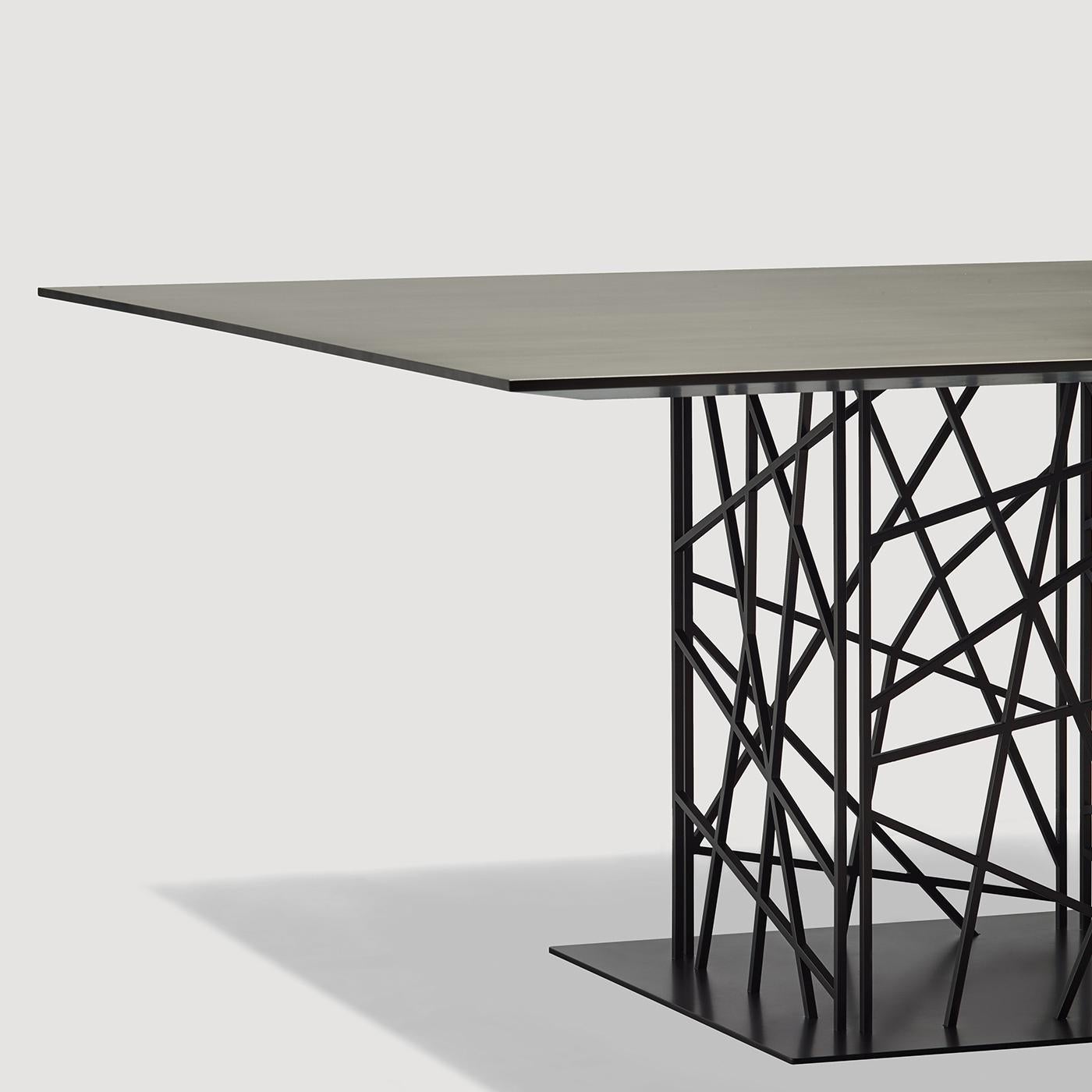 Un tissage géométrique saisissant est l'élément déterminant de la structure de base de cette superbe table à manger. Réalisée en acier, la base est composée de quatre feuilles de textures différentes obtenues par un travail de découpe au laser. Le